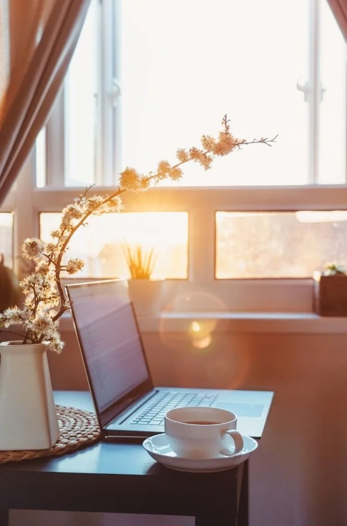 A cozy workspace by a window with sunlight representing counseling and consulting for therapists and therapy practices.