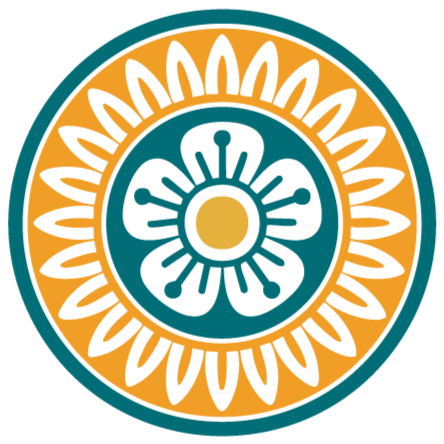 Circular emblem from a Mah Jongg tile with a central flower design, surrounded by two concentric rings, on a blue background with black, orange, and blue details.