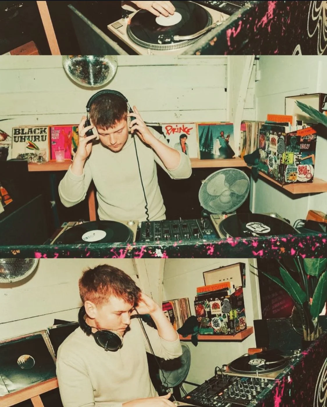A young man DJing at a vinyl record shop with turntables and a mixer, wearing headphones, with vinyl records on shelves behind him.