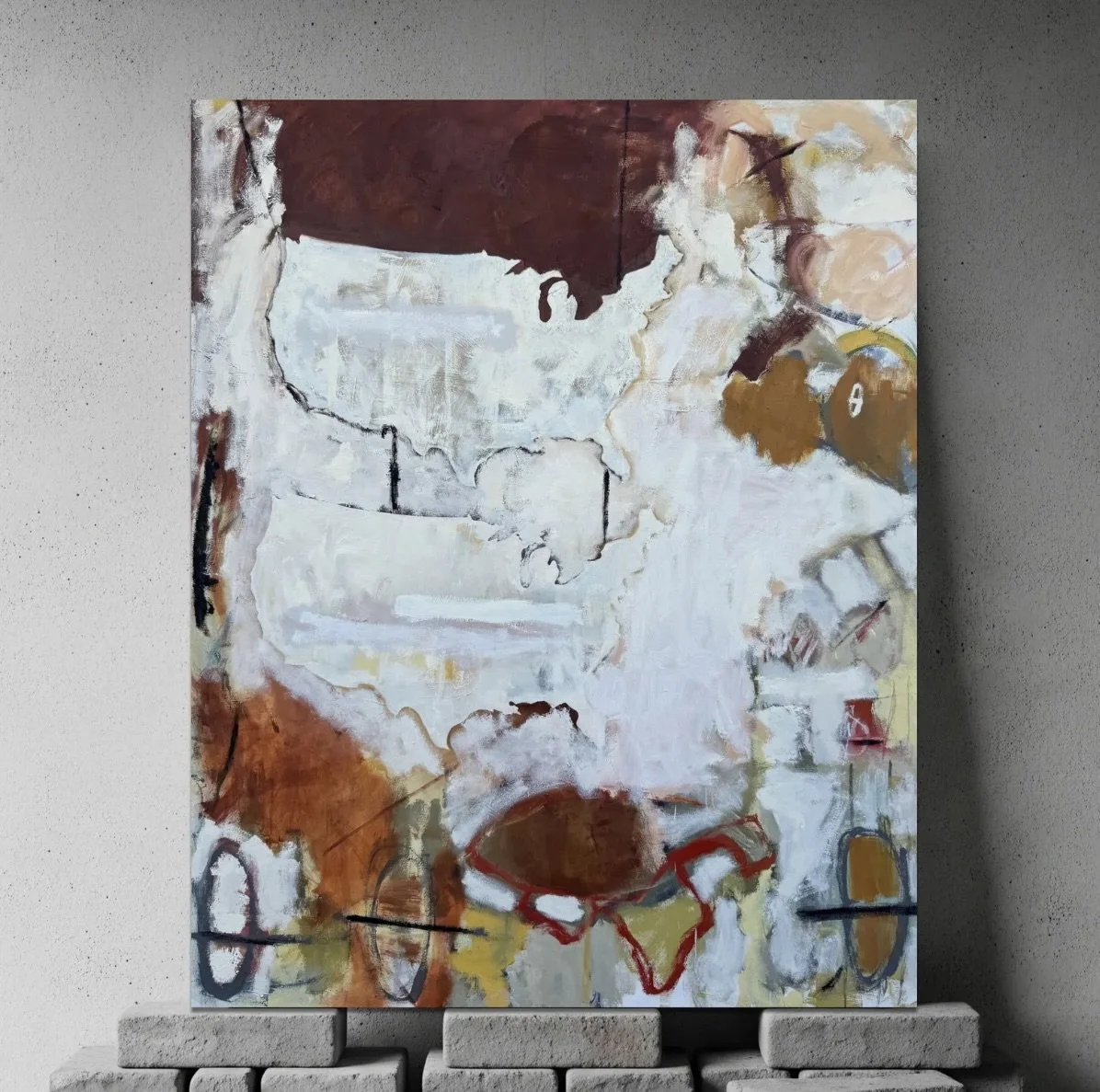 Abstract painting with earthy tones, including white, brown, red, and hints of yellow, mounted on a wall with gray speckled texture, supported by small bricks at the bottom.
