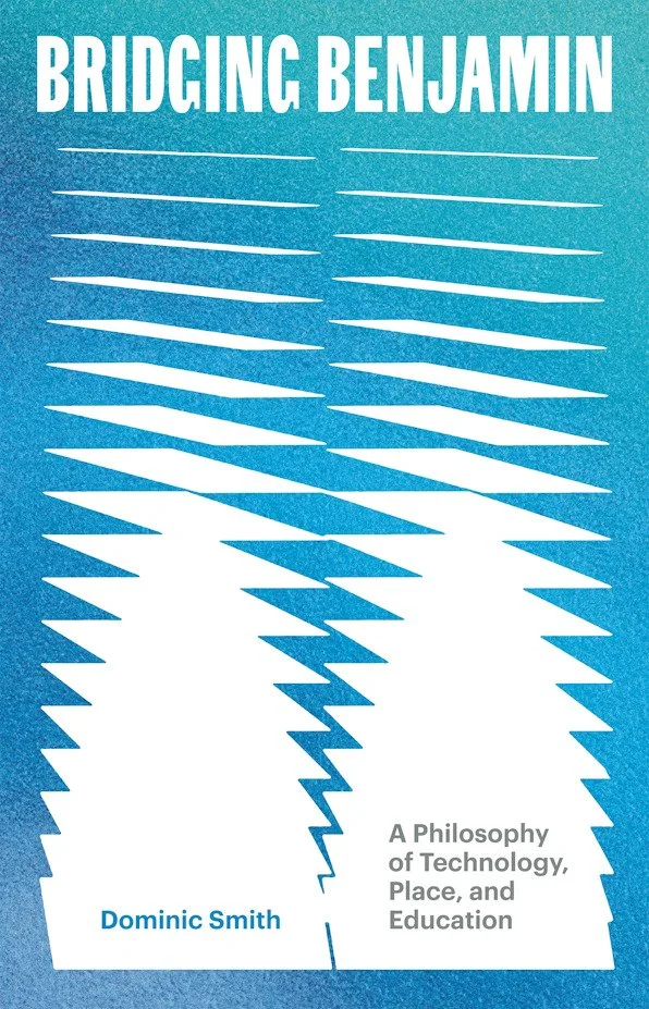 Cover of a book titled "Bridging Benjamin" with a blue background, featuring white zigzag lines connecting two large white shapes resembling stylized faces, and text indicating it is about the philosophy of technology, place, and education by Dominic Smith.
