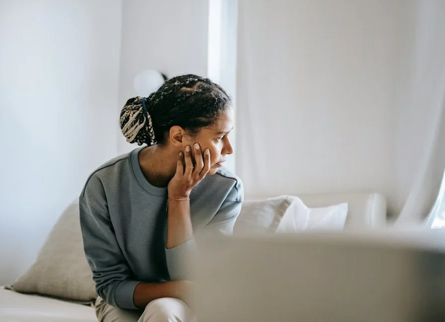 a person rests their hand on chin, deep in thought