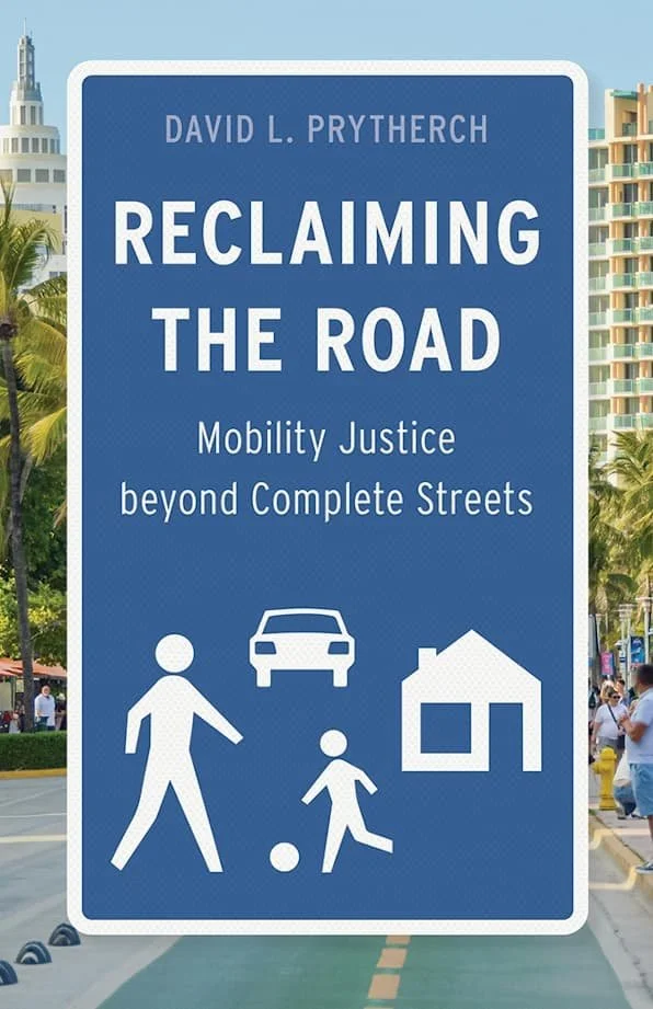 A sign advocating for mobility justice beyond complete streets, featuring symbols of a pedestrian, a child with a ball, a car, and a house, with a cityscape and palm trees in the background.