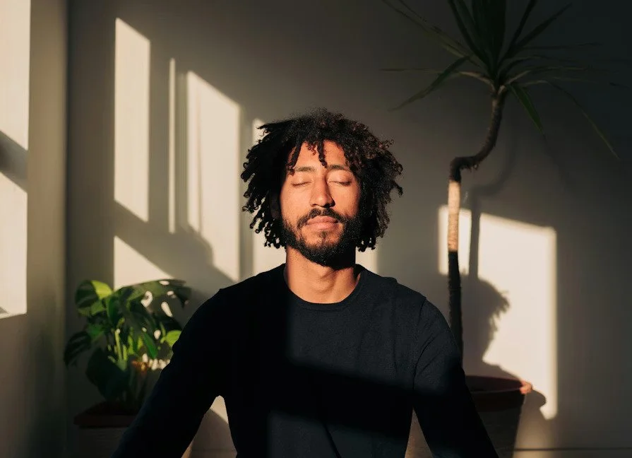 person closing eyes and meditating before therapy session