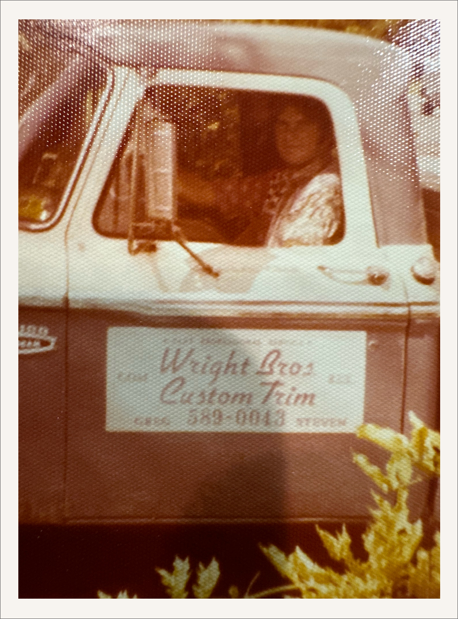A small vintage pickup truck with a business signed painted on the truck