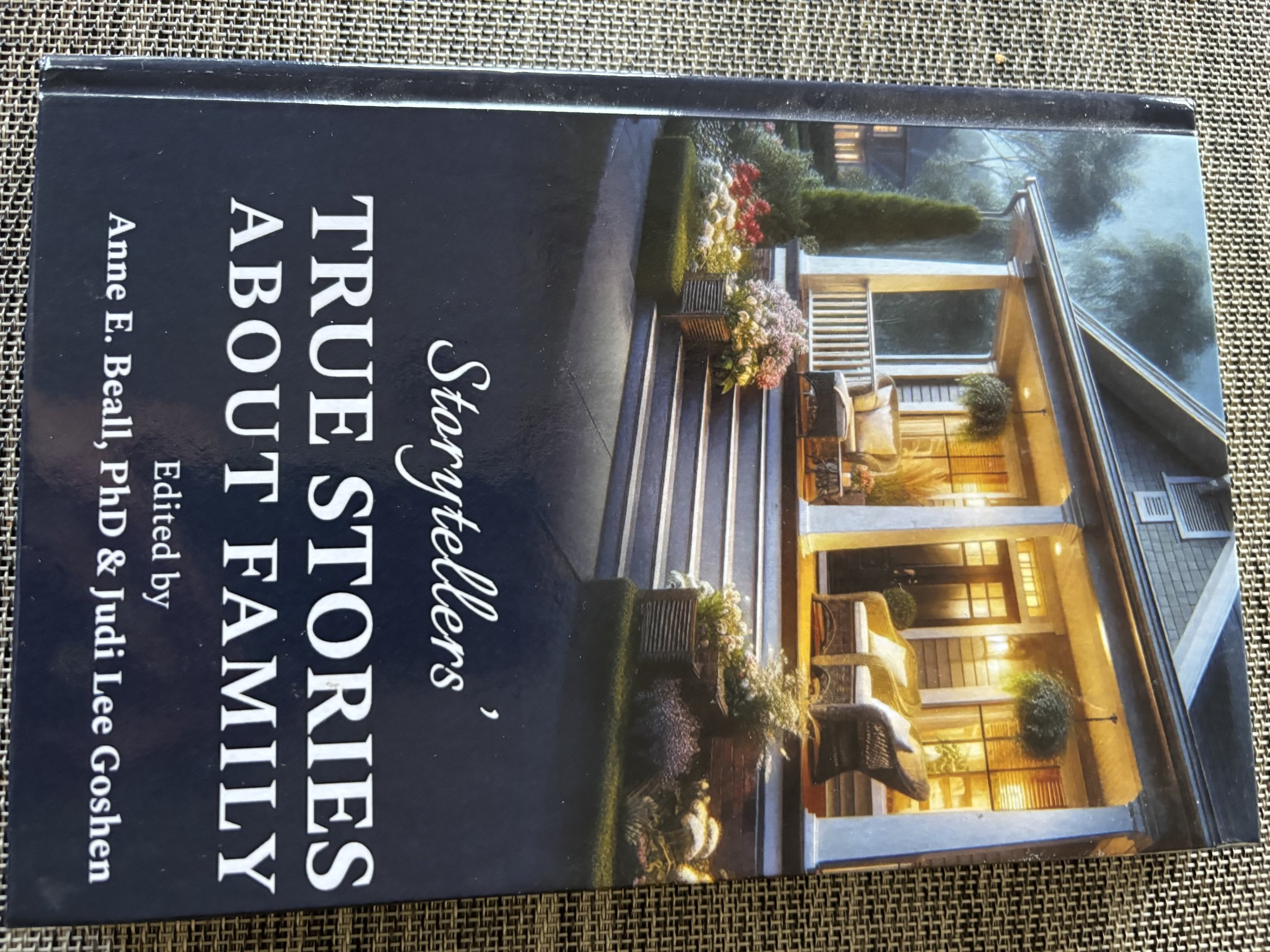 Book cover titled 'Steve Stoller’s True Stories About Family' by Ame E. Beall, featuring a photograph of a house with a porch, outdoor seating, potted plants, and warm lighting.