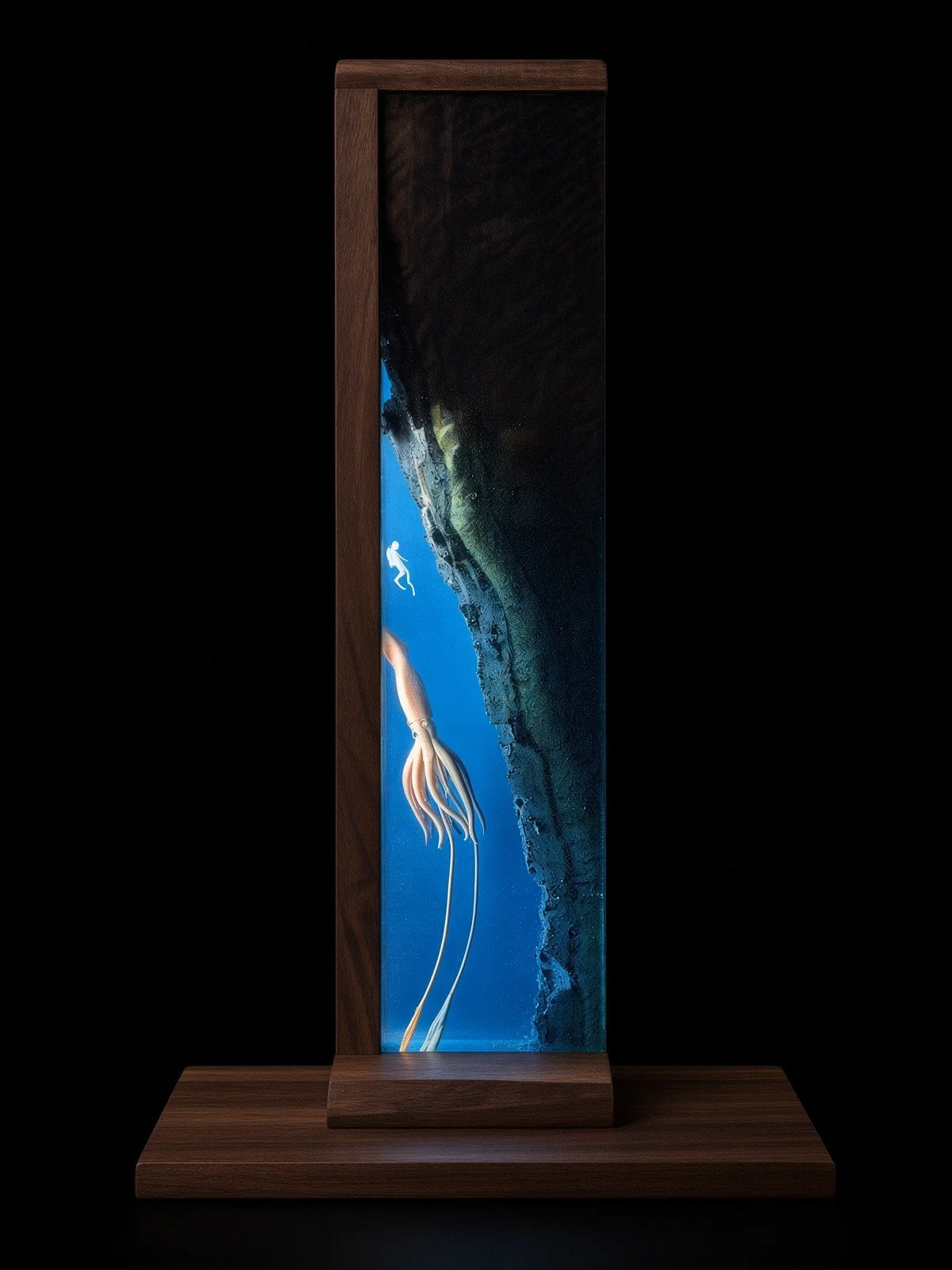 A vertical illuminated display featuring an underwater scene with a diver and a squid, framed in dark wood, set against a black background.