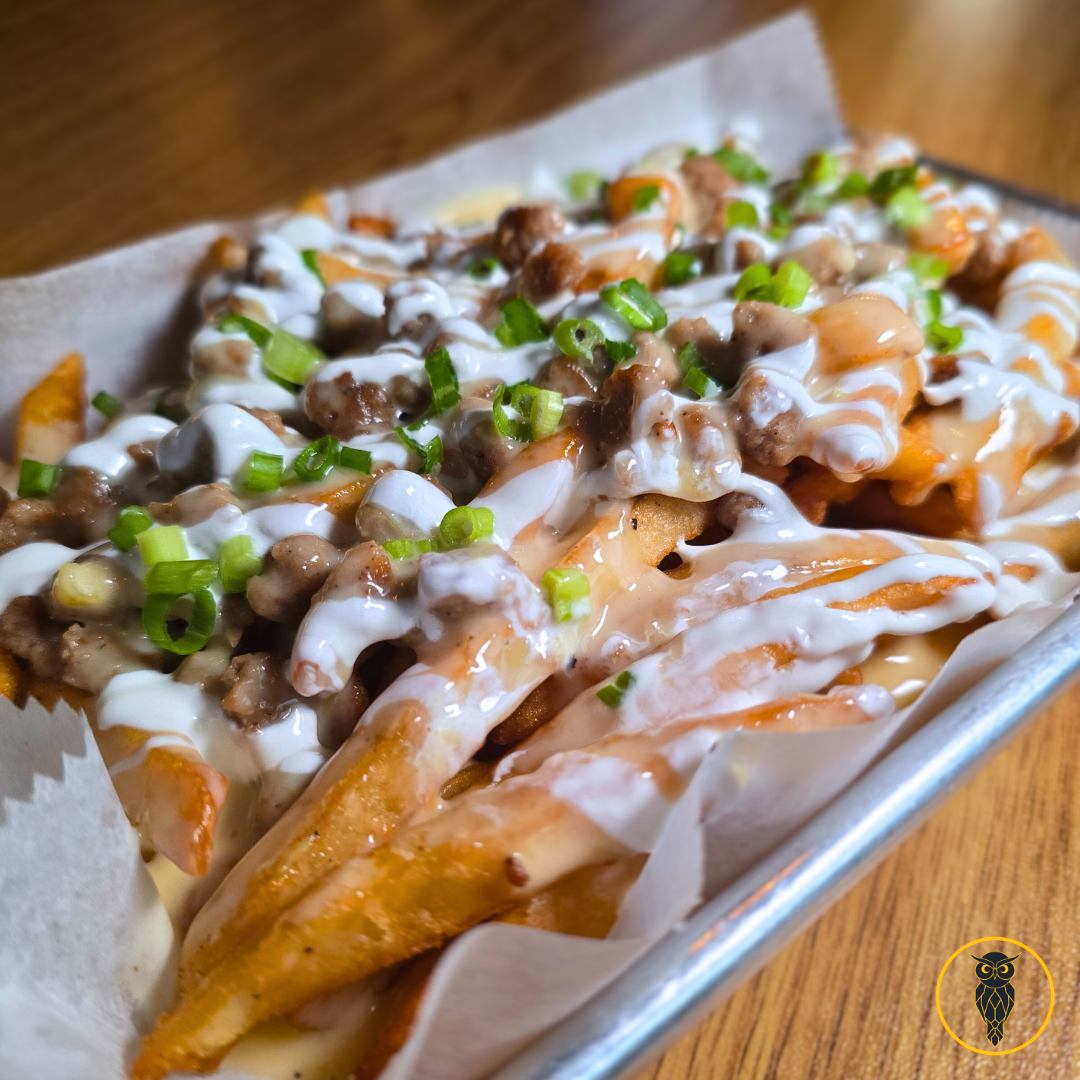 Loaded fries topped with sour cream, green onions, cheese, and ground beef.