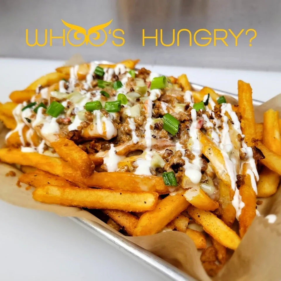 Loaded French fries topped with ground beef, cheese, chopped green onions, and drizzled with white sauce and BBQ sauce.