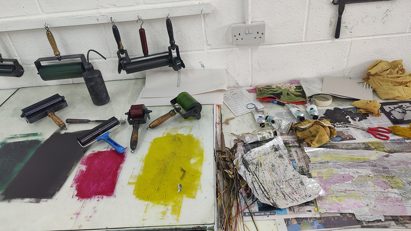 Atelier d'art avec outils de décoration, impressions de couleur, tubes de peinture, papier peint, matériel de peinture, gants et autres fournitures_artistique