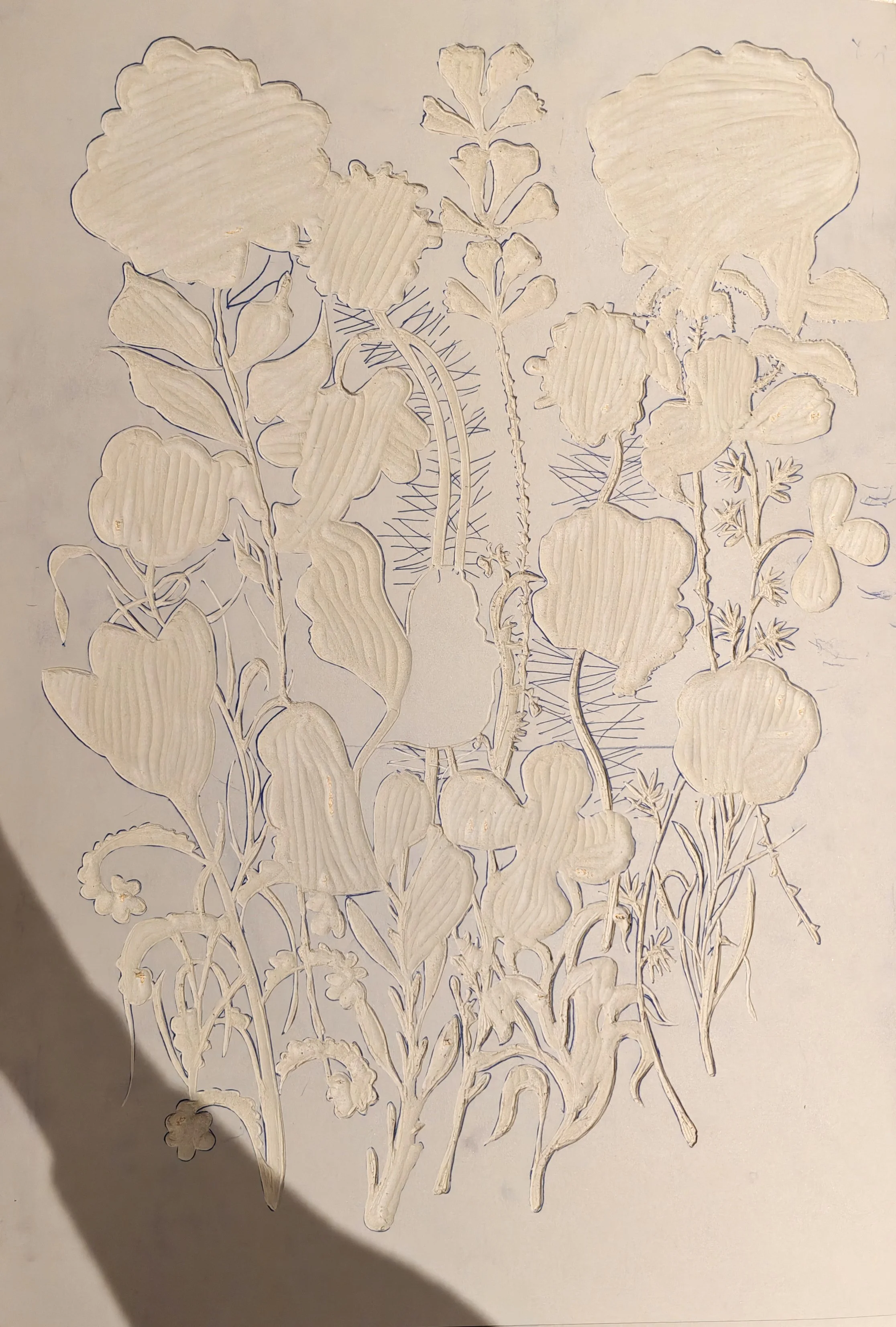 Découpe sur linoleum de feuilles et de fleurs de plantes différentes en papier blanc, avec des contours tracés en bleu, assemblées pour créer une composition botanique.