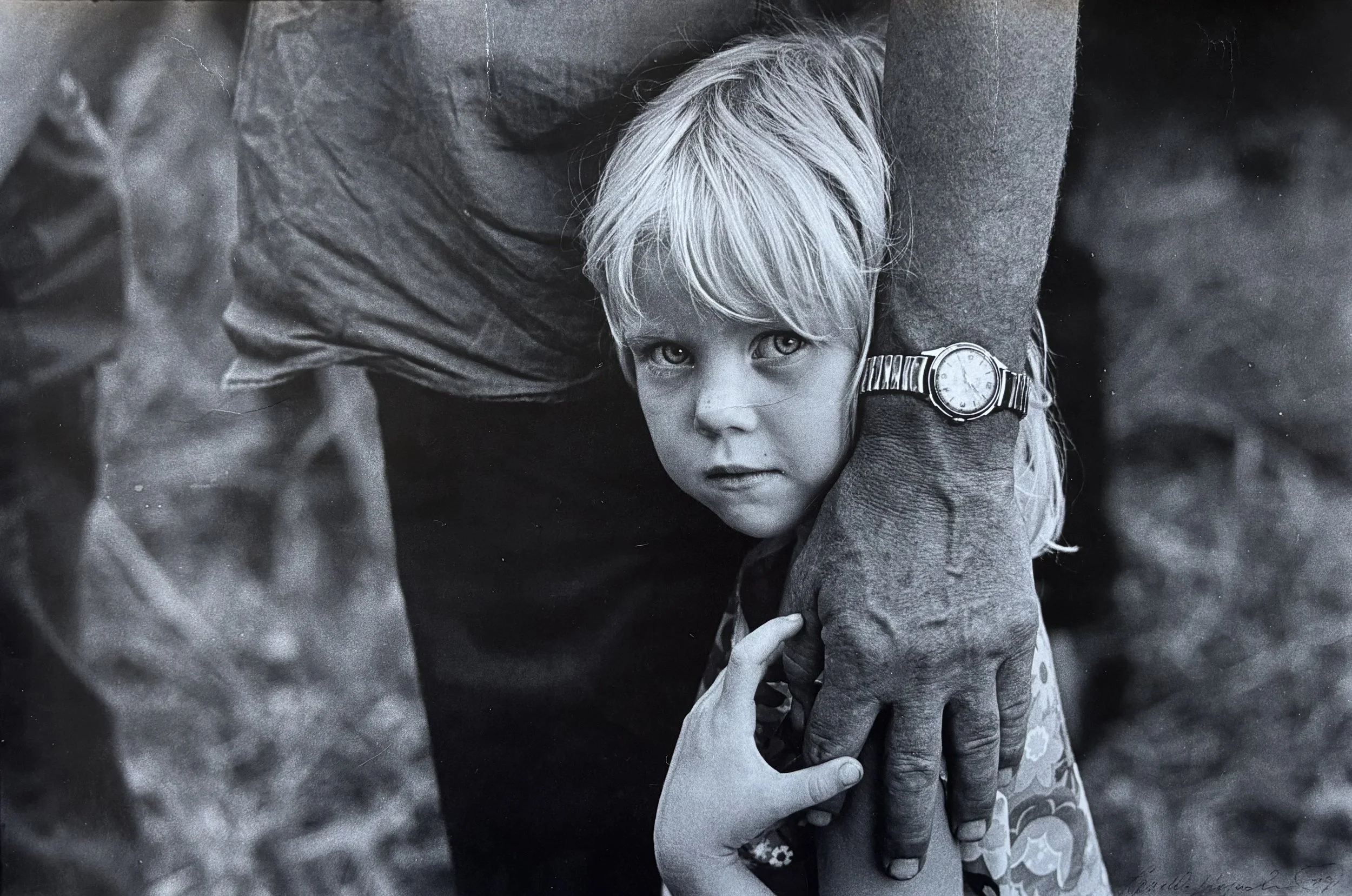 A-Young-Child-Clings-To-A-Companion-Their-Gaze-Unforgettable-Inviting-Us-To-Meet-Their-Eyes-In-A-Moment-Of-Profound-Historical-Weight-Where-Silence-Carries-Stories-Words-Cannot.