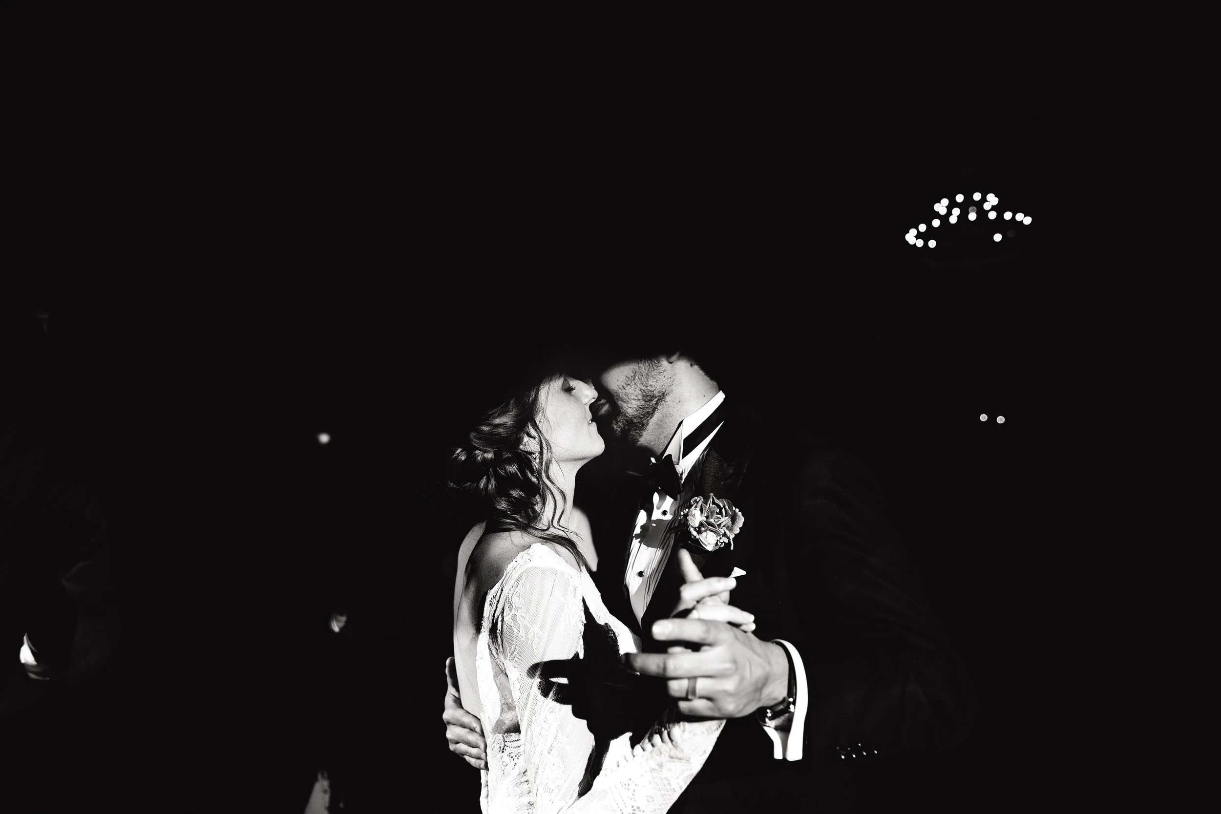 A black-and-white photograph of a bride and groom dancing closely at a wedding, with their faces near each other and their hands clasped.  Nashville Wedding.  Wedding Photography by Sowing Clover Photography.