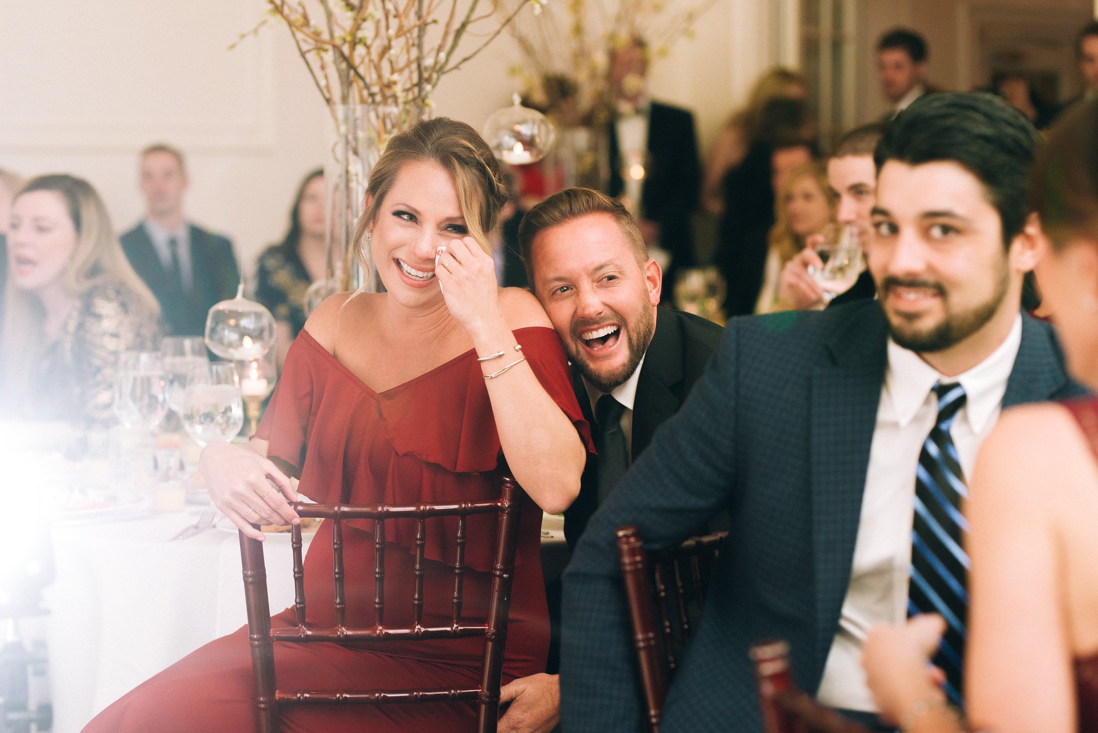 People at a formal wedding reception laughing and enjoying themselves at a decorated banquet hall at the Reed House in Chattanooga, TN.