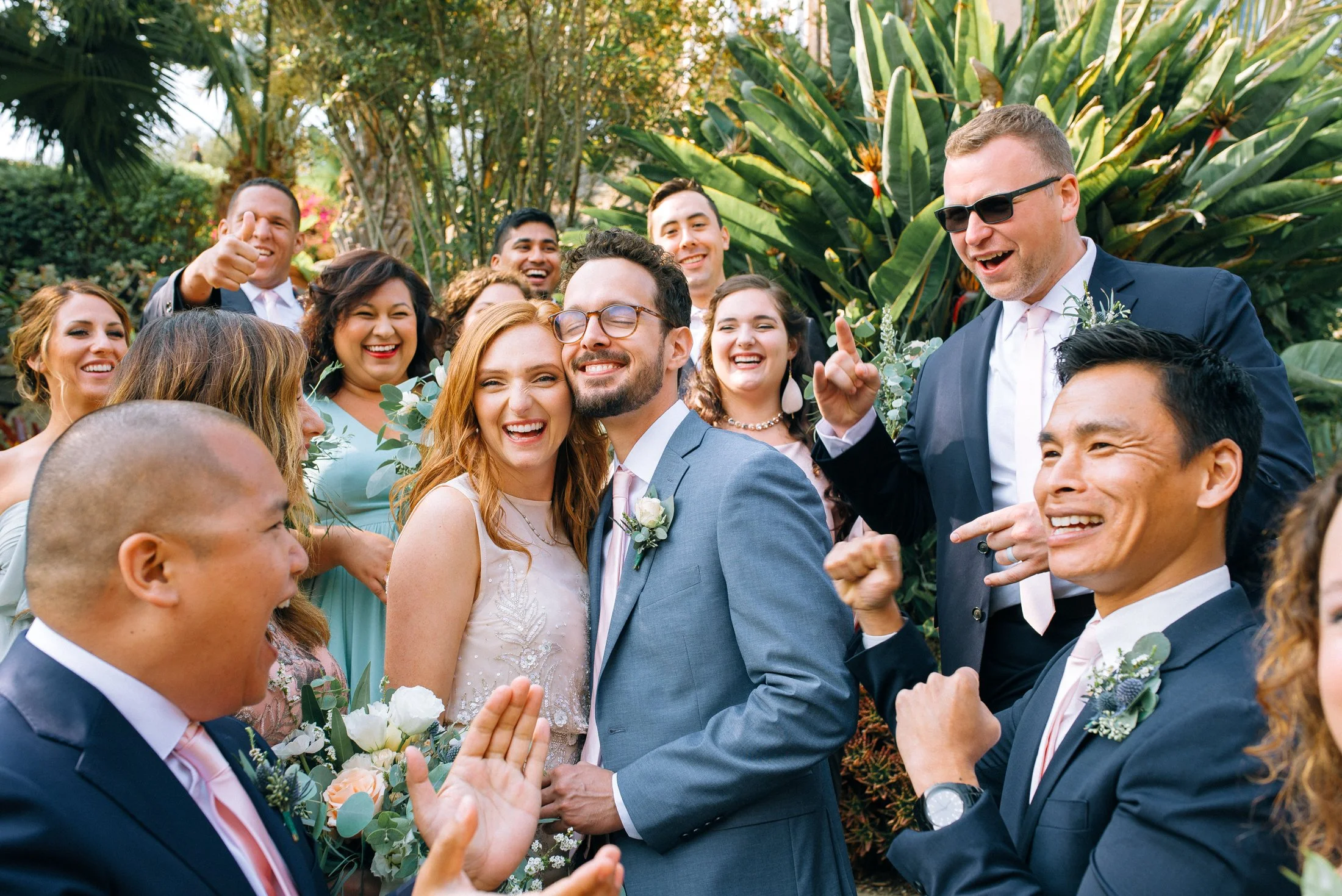 A joyful group of wedding guests, including the bride and groom, celebrating outdoors with big smiles and laughter in San Fransisco. Wedding Photography by Sowing Clover Photography.