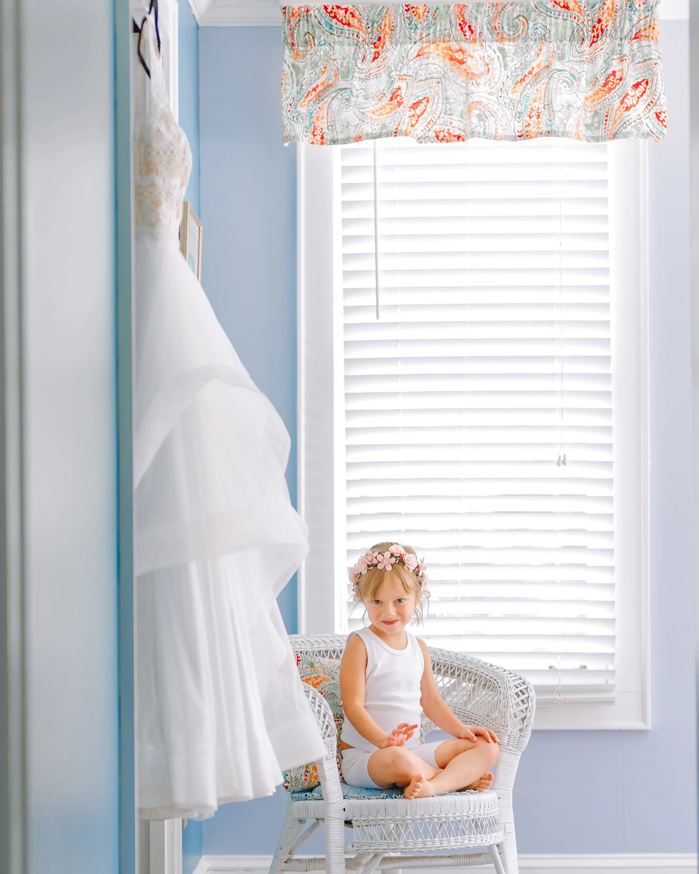 Flower girl sitting next to wedding dress for Atlanta based wedding. Wedding Photography by Sowing Clover Photography.