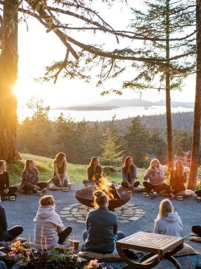 A group of people sitting in the forest, enjoying a mindful conversation inspired by Ginkgo Wellness Studio Shinrin-yoku (forest bathing).