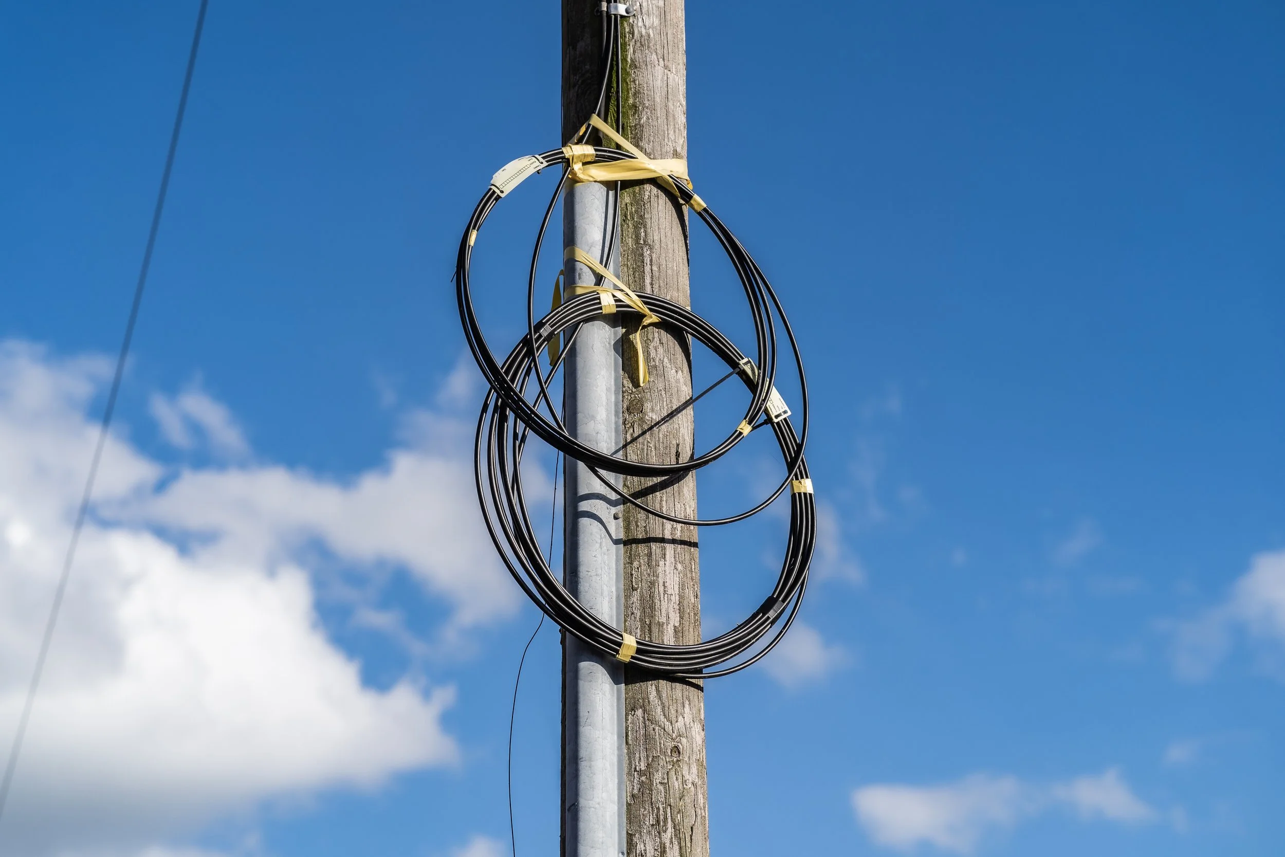Fiber cable reels staged at a yard as operators slow new market expansion to protect returns