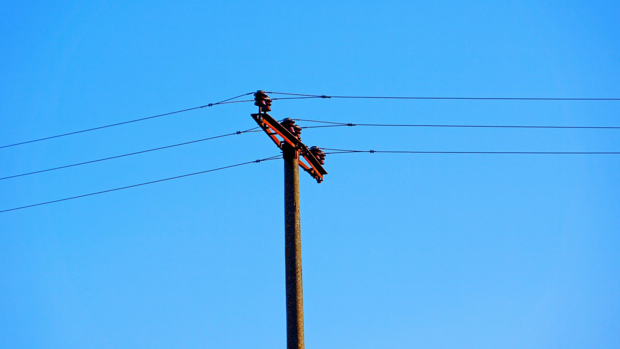 Aging copper telecommunications cables on utility poles compared to modern fiber optic infrastructure