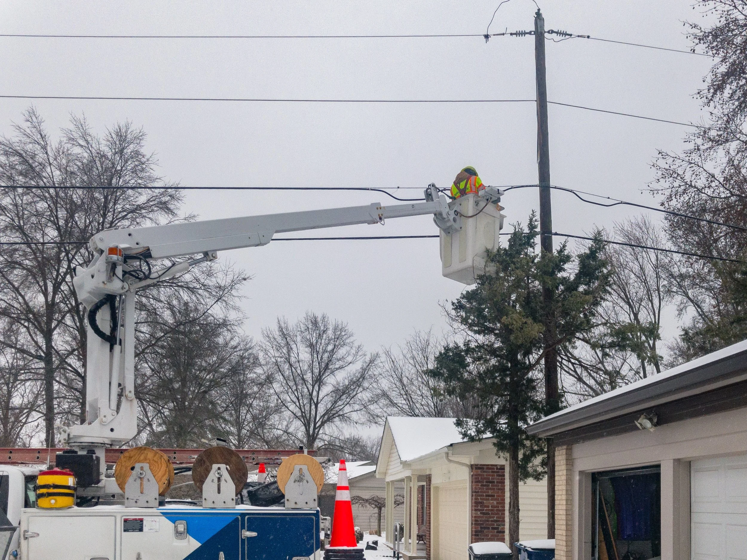 Storm-damaged aerial fiber optic cable attached to a utility pole requiring inspection and repair