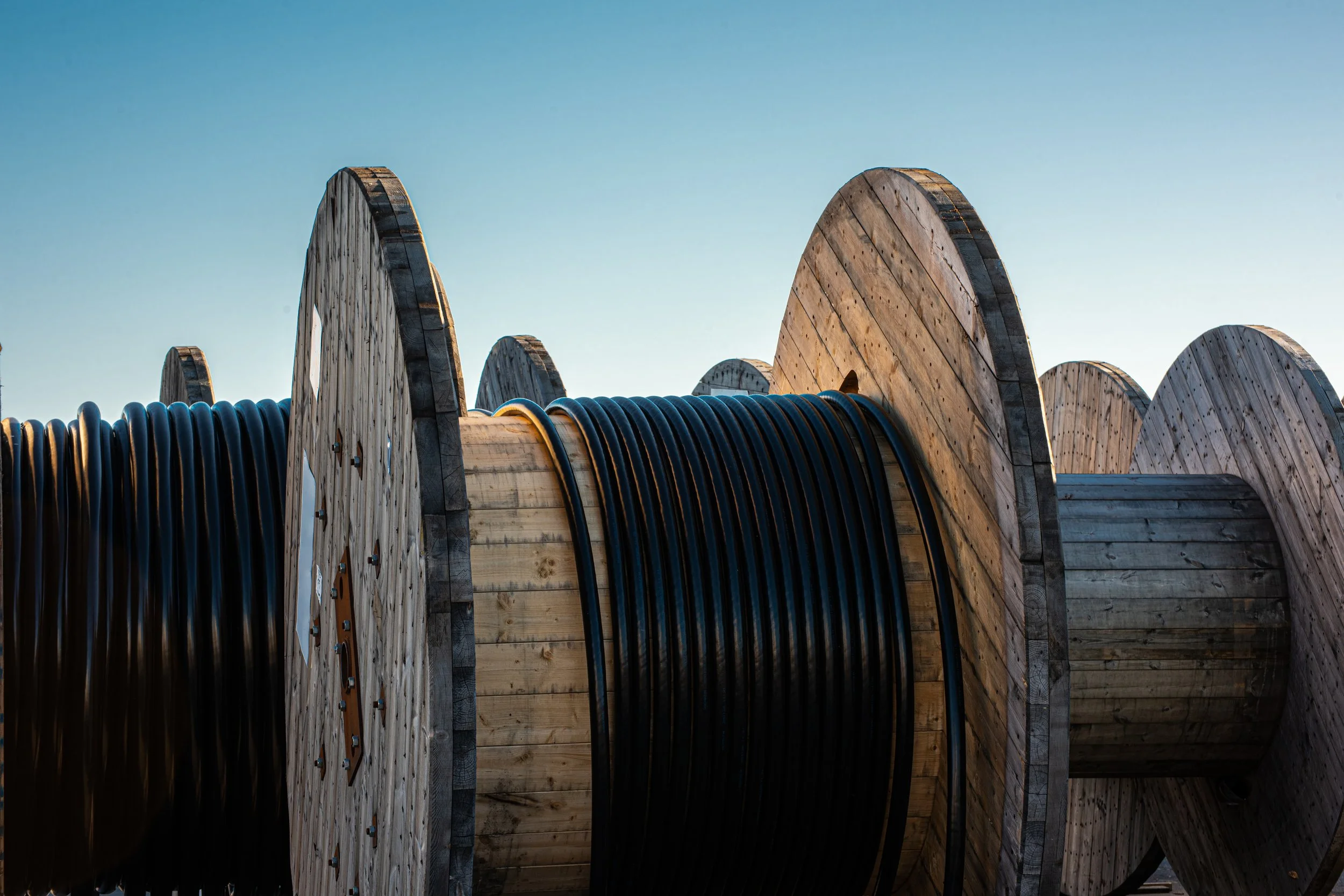 Spare fiber reels, closures, and strand hardware staged on shelving so a restoration crew can reach them at any hour.