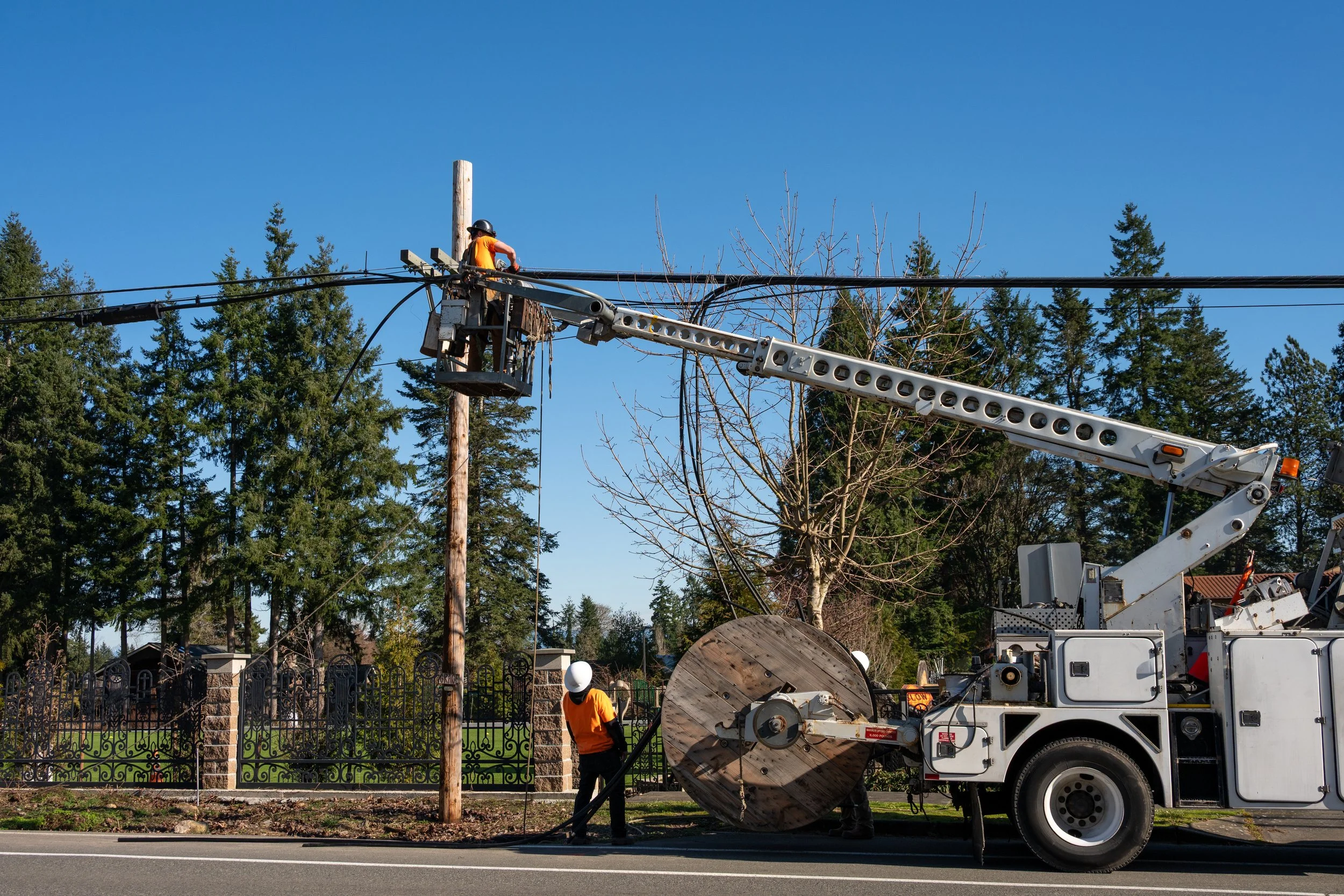 Pennsylvania One Call locate ticket on a tablet beside a pole-setting auger truck at a fiber jobsite