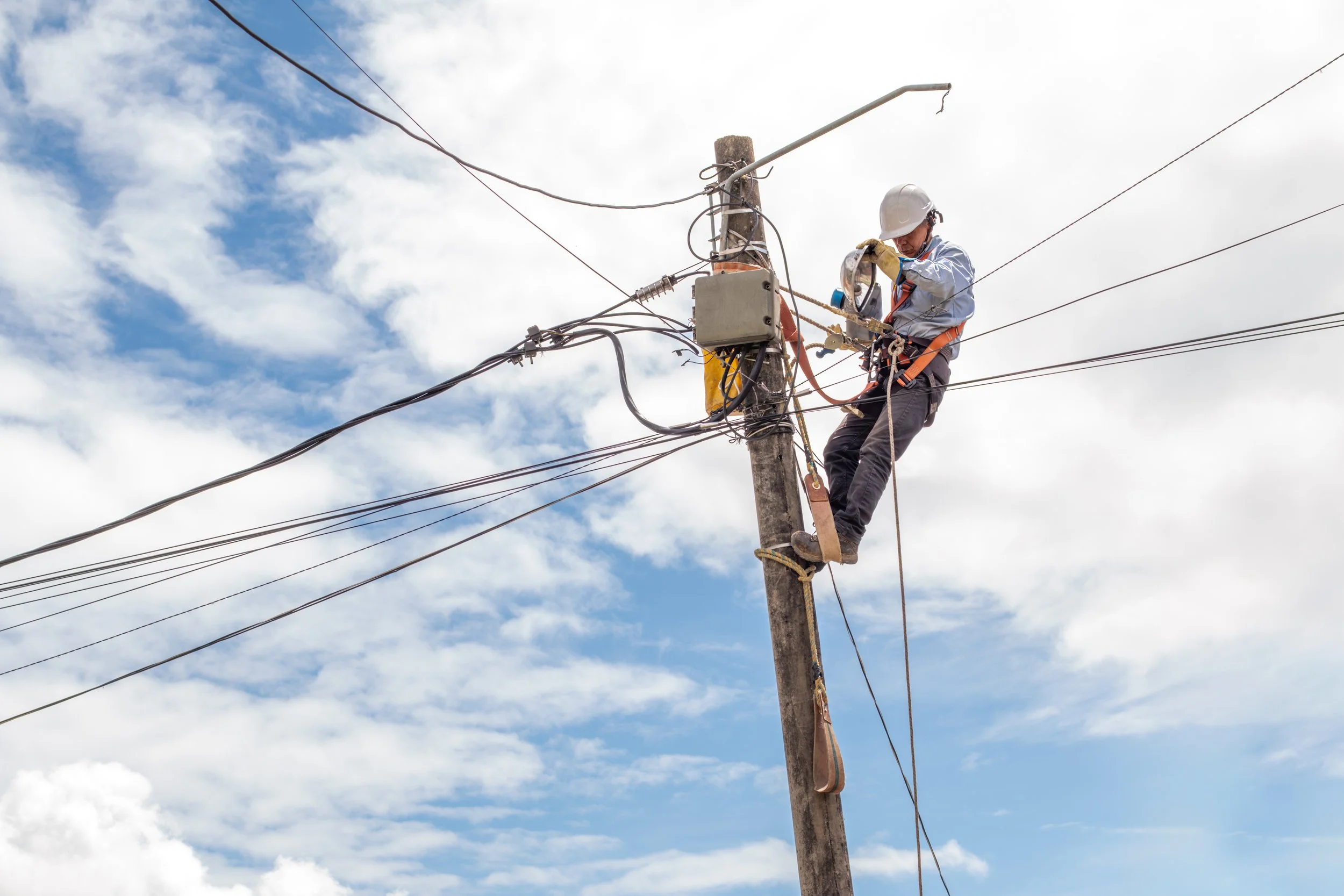 Crew working from a bucket to remove legacy cable and install fiber on the same pole route