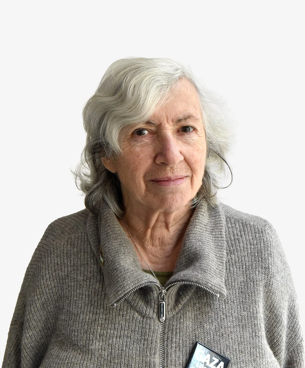 Femme aux cheveux mi-long blanc. Elle porte un pull gris.