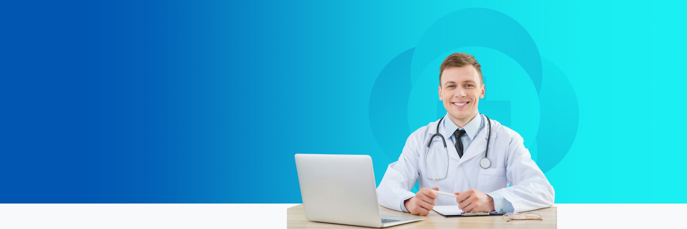 A smiling male doctor sitting at a desk with a laptop and clipboard in front of a blue background.