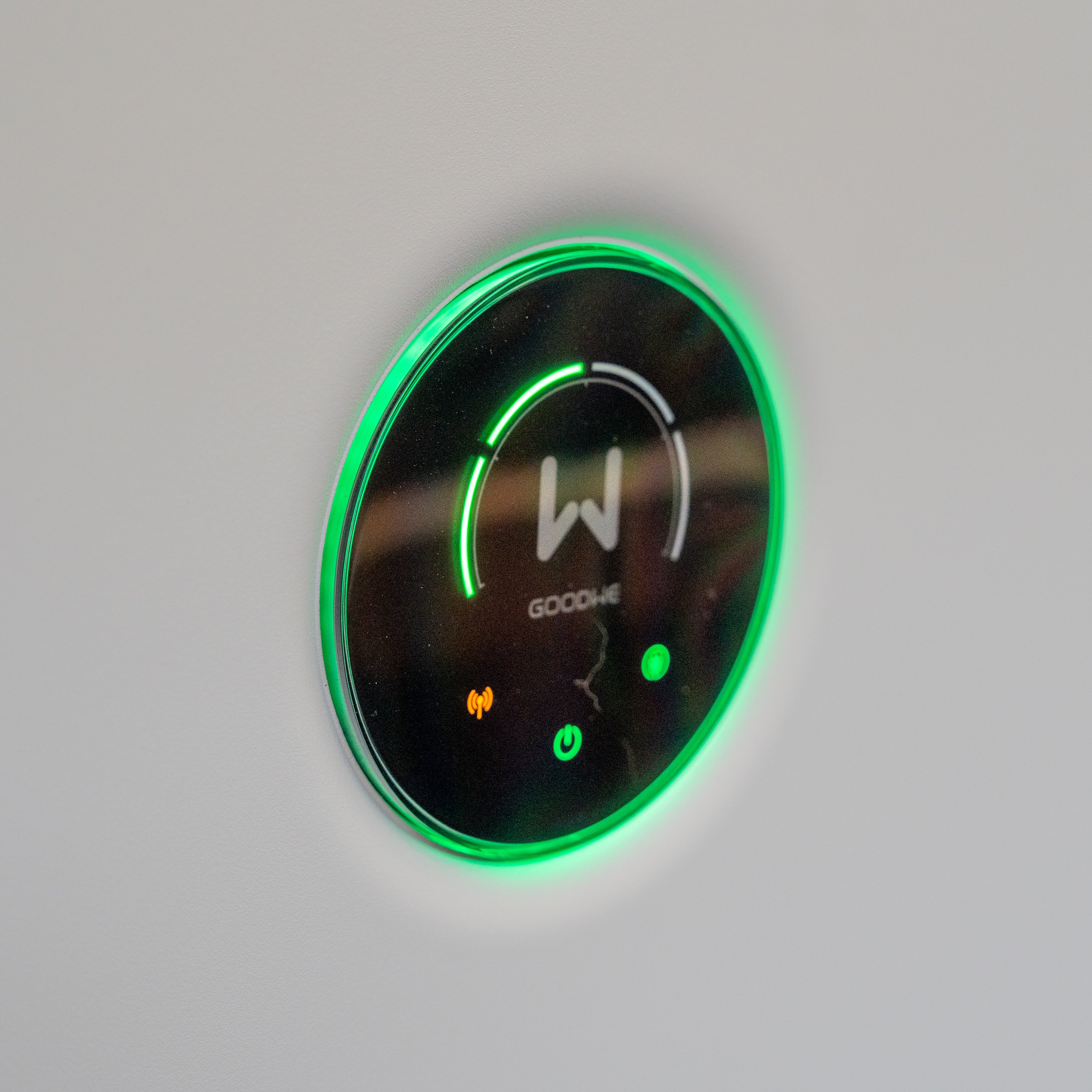 Circular digital control panel with green LED lights and icons, possibly on a modern appliance or device.