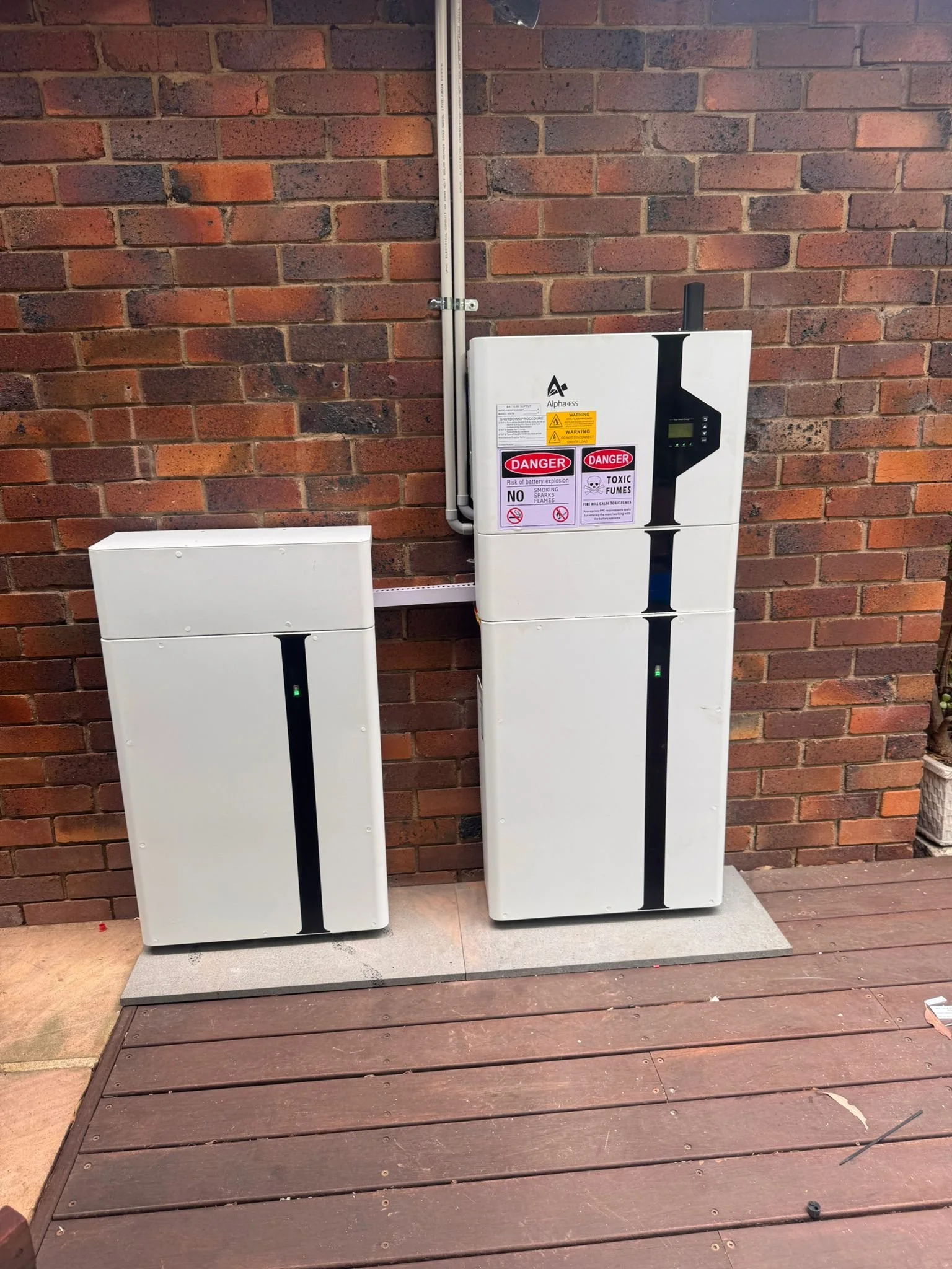 Residential solar battery storage units installed outdoors for storing excess solar energy generated by rooftop solar panels.