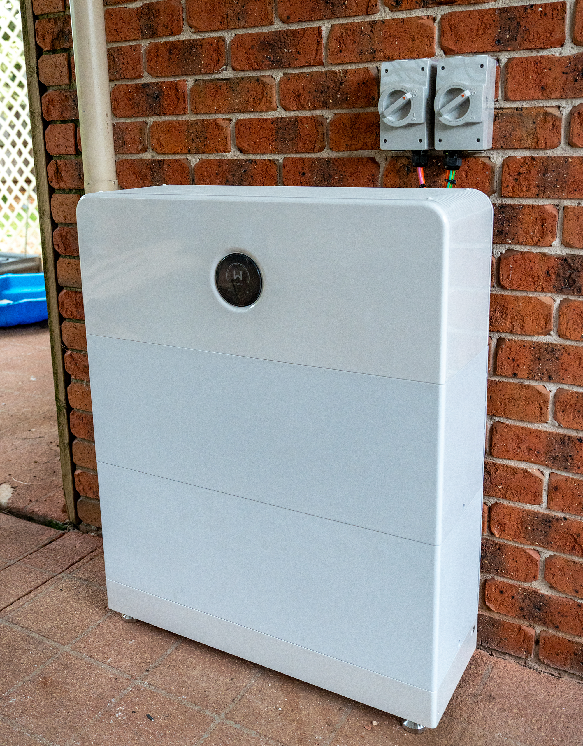 Outdoor home solar battery unit connected to electrical system for solar energy storage and backup power.