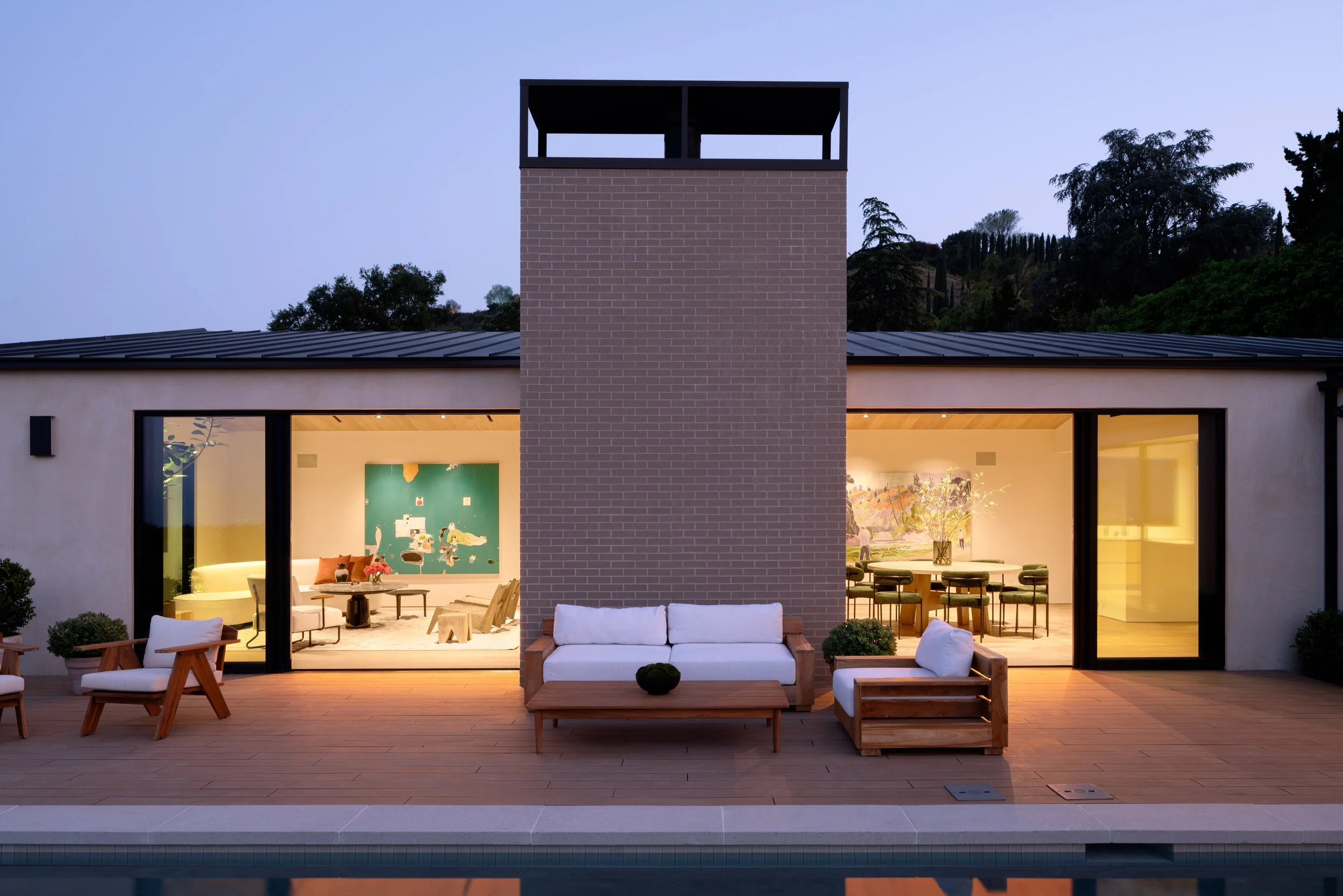 Contemporary backyard with outdoor lounge, pool, and seamless indoor-outdoor living at dusk, remodeled by JBurton General Contractor in Beverly Crest, Los Angeles.
