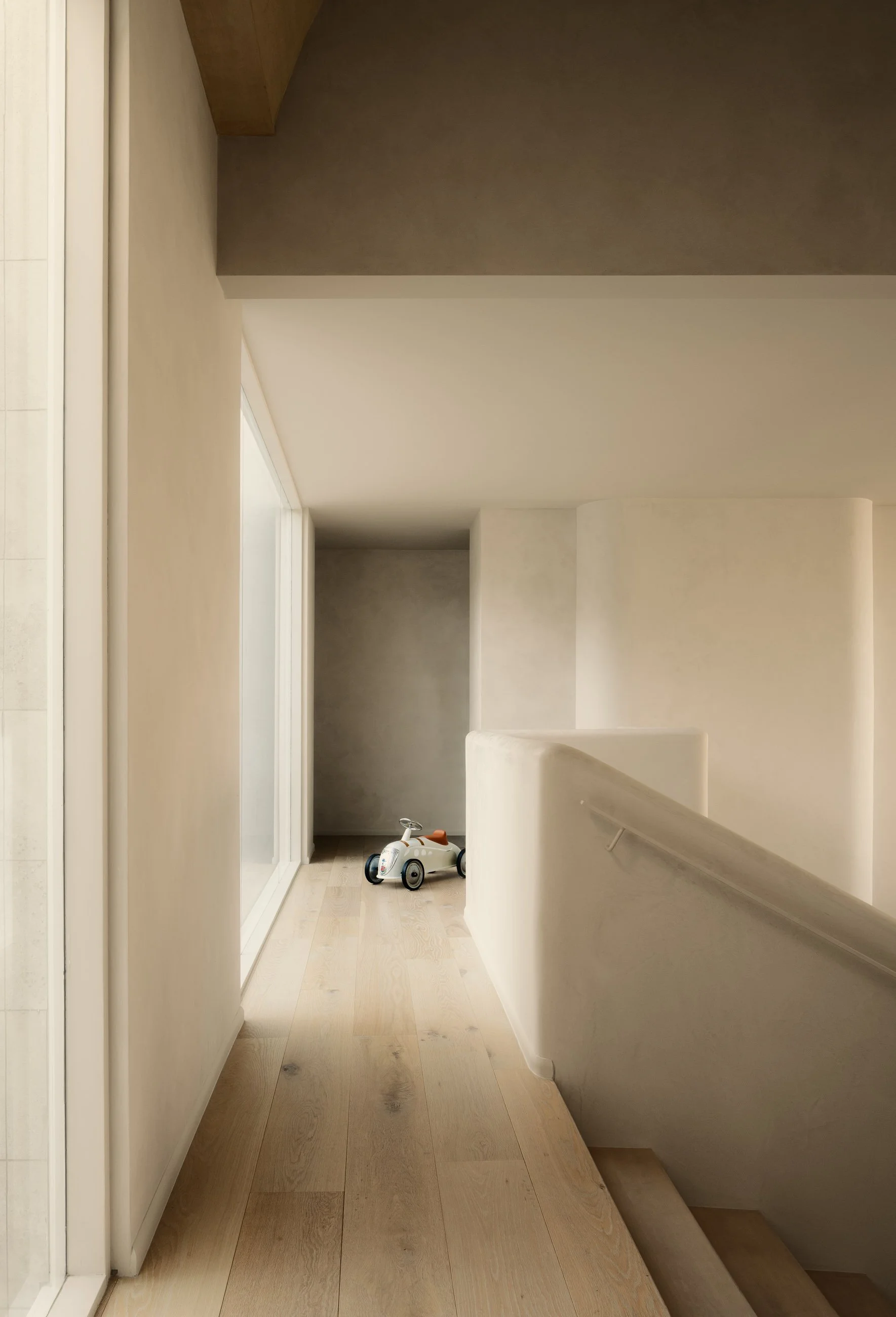 Bright upper hallway with smooth plaster walls and minimalist architectural detailing, completed by JBurton General Contractor for a luxury home remodel in Benedict Canyon, Los Angeles.