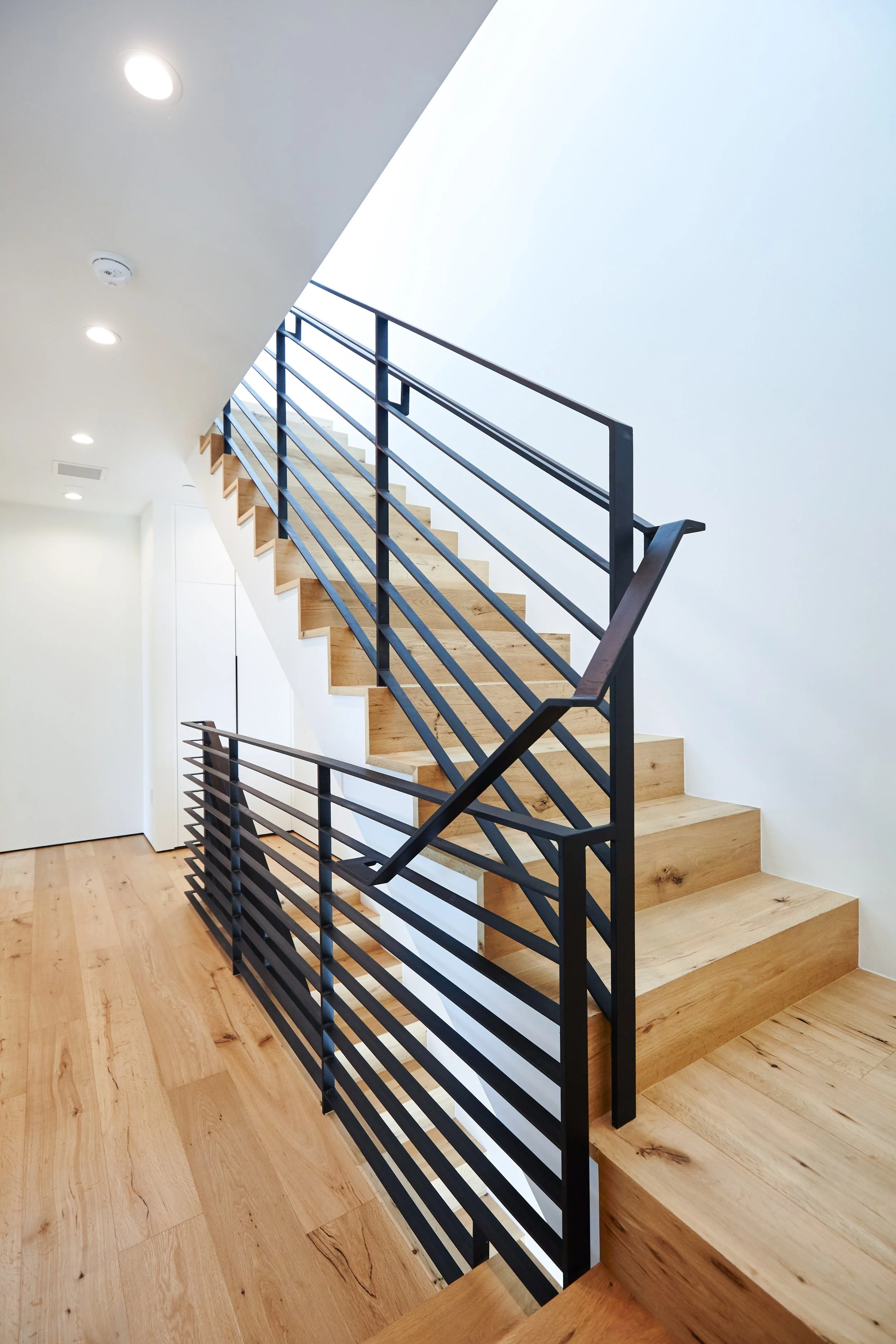 Custom steel stair railing and oak staircase crafted by JBurton General Contractor in a modern Faircrest Heights residence.