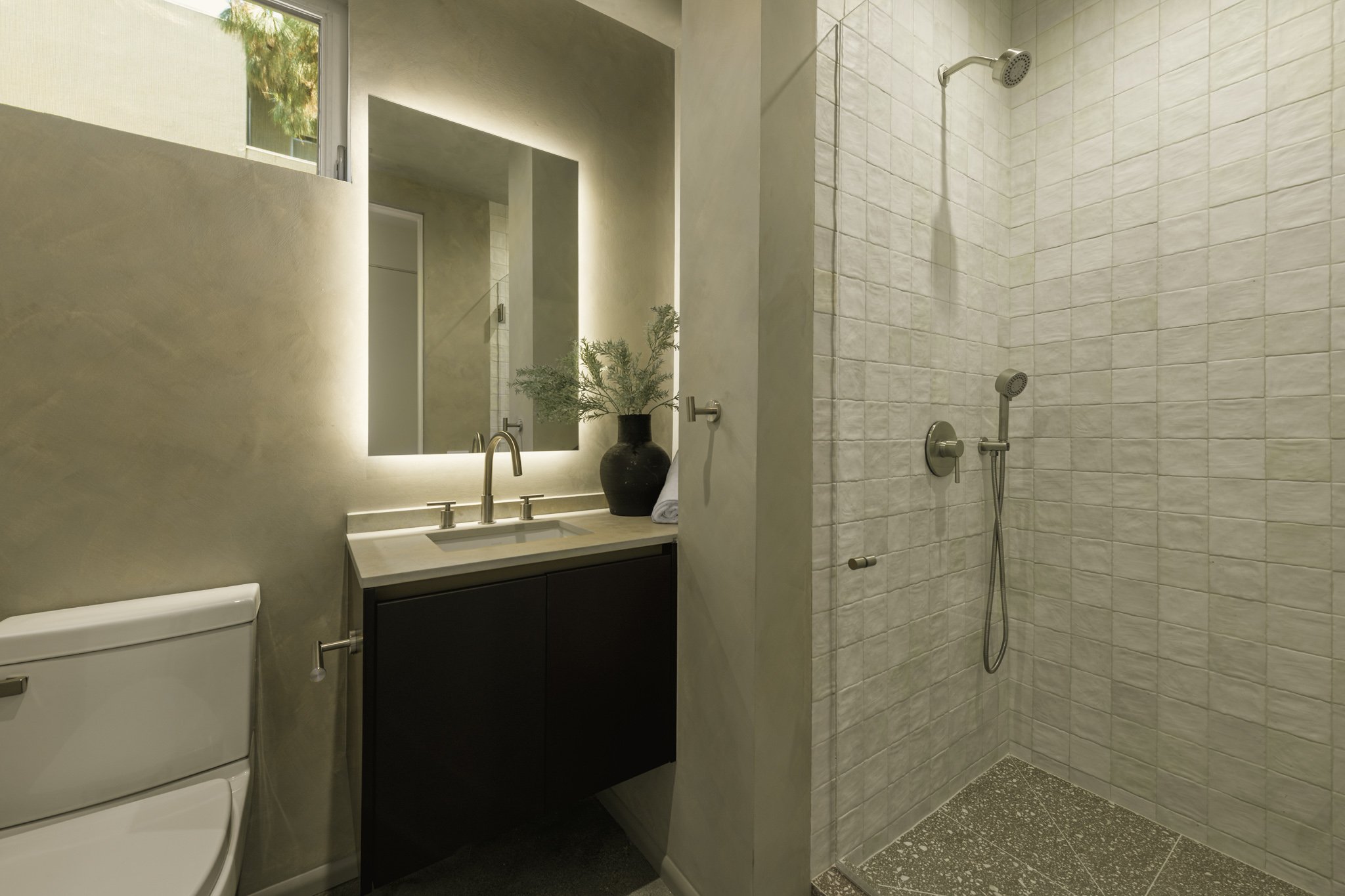 Contemporary bathroom with a floating vanity, illuminated mirror, and walk-in tiled shower, built by JBurton General Contractor for luxury townhomes in Silver Lake, Los Angeles.