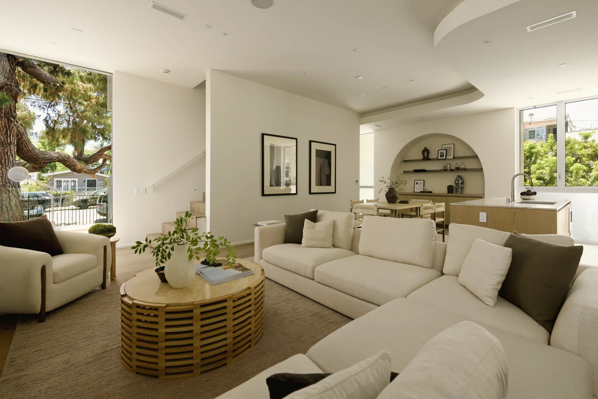 Open-concept living room with floor-to-ceiling windows, contemporary furnishings, and abundant natural light, built by JBurton General Contractor for luxury townhomes in Silver Lake, Los Angeles.