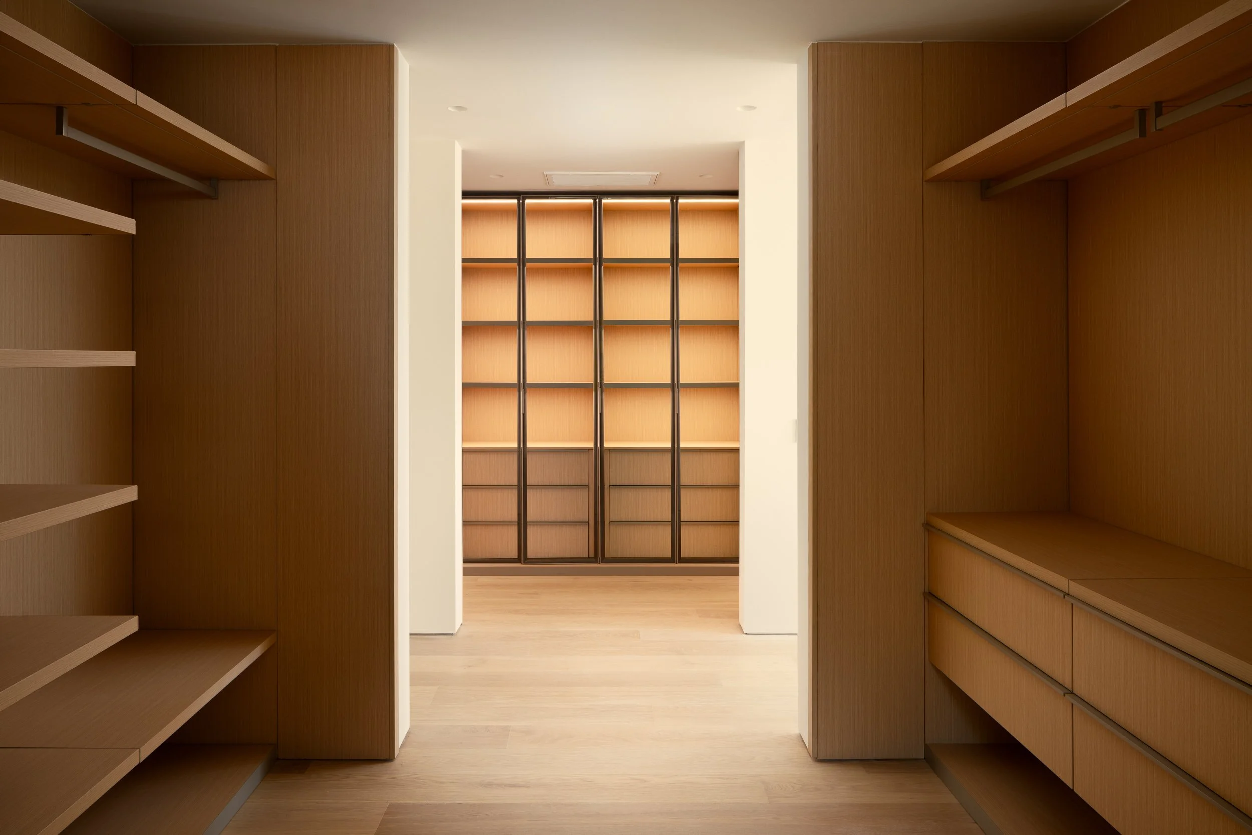 Spacious walk-in closet with custom built-in storage and illuminated shelving, remodeled by JBurton General Contractor in Beverly Crest, Los Angeles.