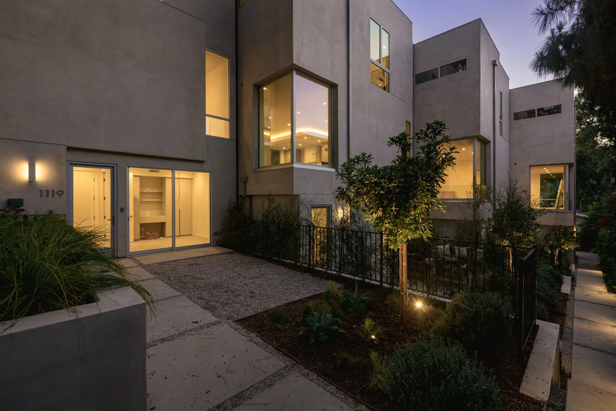 Contemporary townhome exterior illuminated at dusk, showcasing modern architecture and landscape lighting, built by JBurton General Contractor in Silver Lake, Los Angeles.