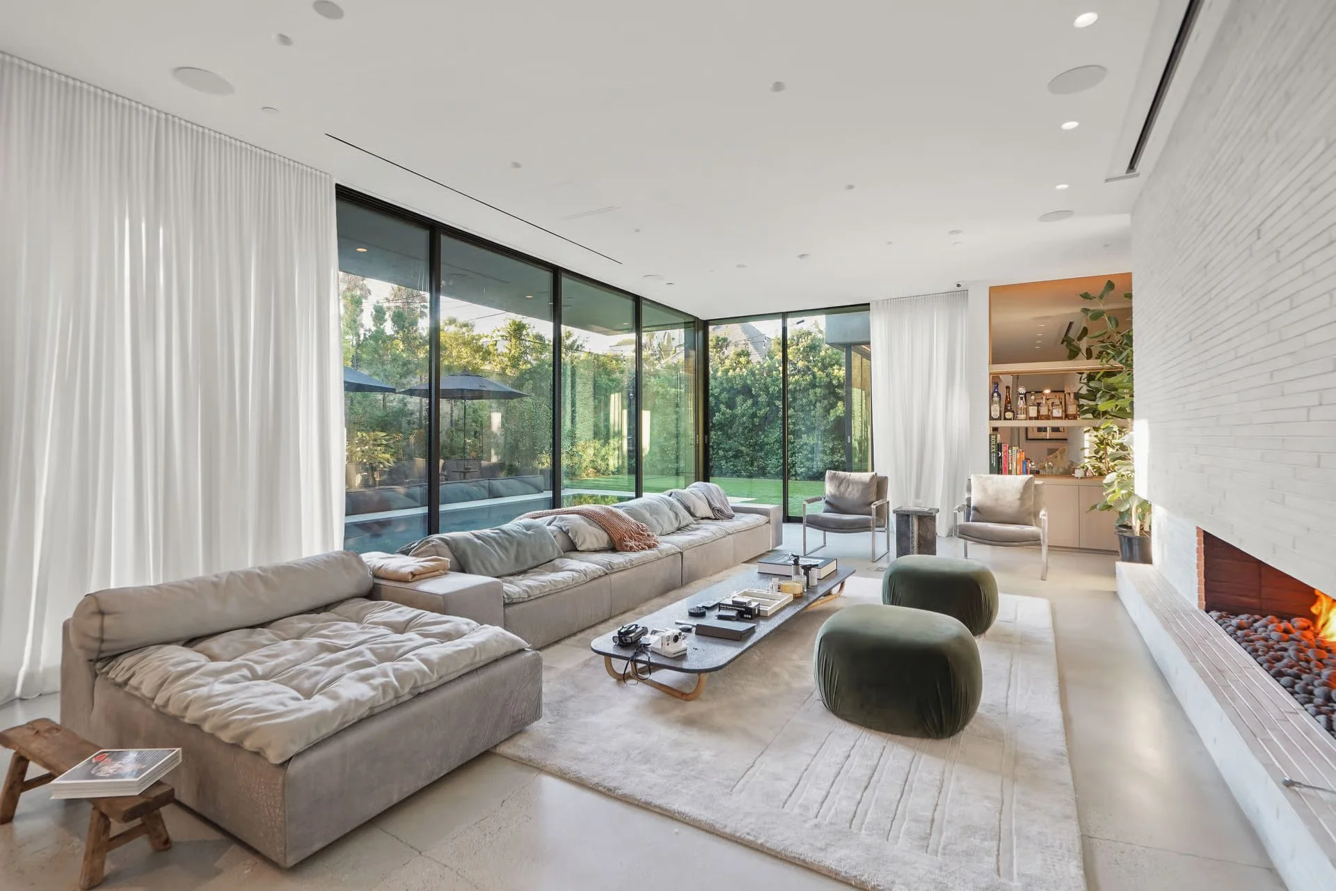Open-concept living room with floor-to-ceiling glass, custom shelving, and seamless indoor-outdoor living, remodeled by JBurton General Contractor in Beverly Grove, Los Angeles.