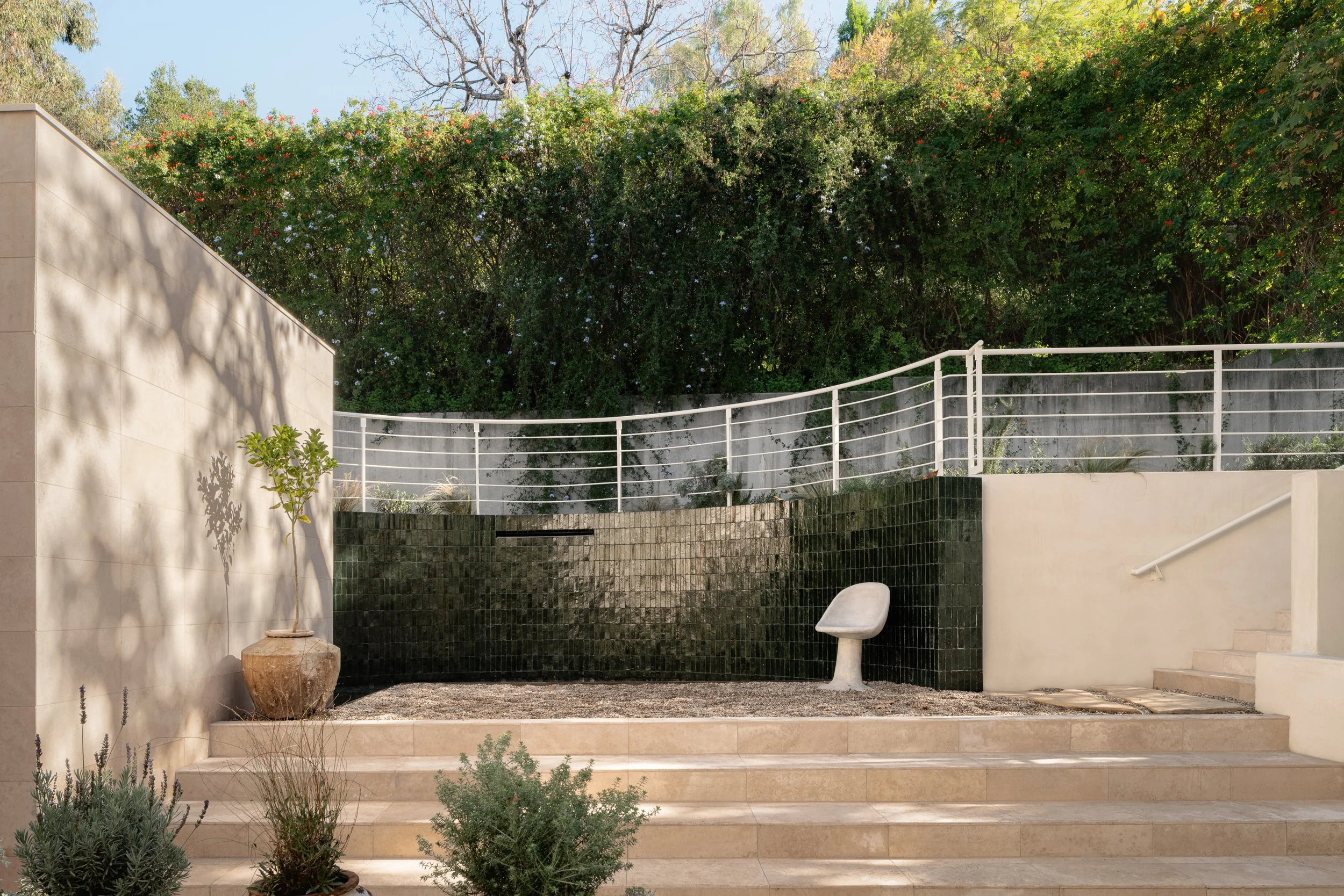 Contemporary courtyard featuring a tiled water feature, terraced landscaping, and outdoor gathering space, completed by JBurton General Contractor in Benedict Canyon, Los Angeles.