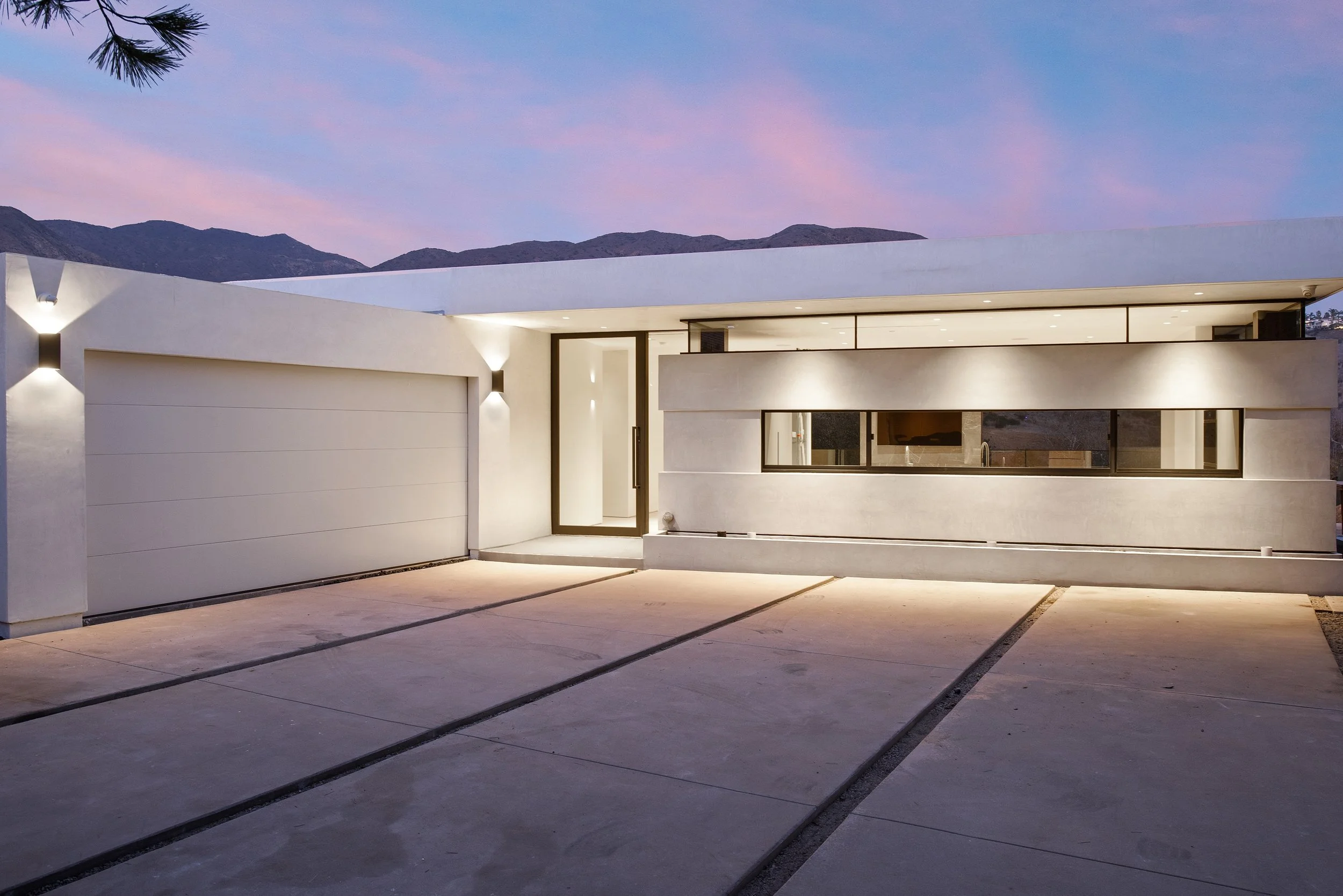 Custom Malibu residence at dusk showcasing clean architectural lines, integrated landscape lighting, and seamless indoor-outdoor living by JBurton General Contractor.