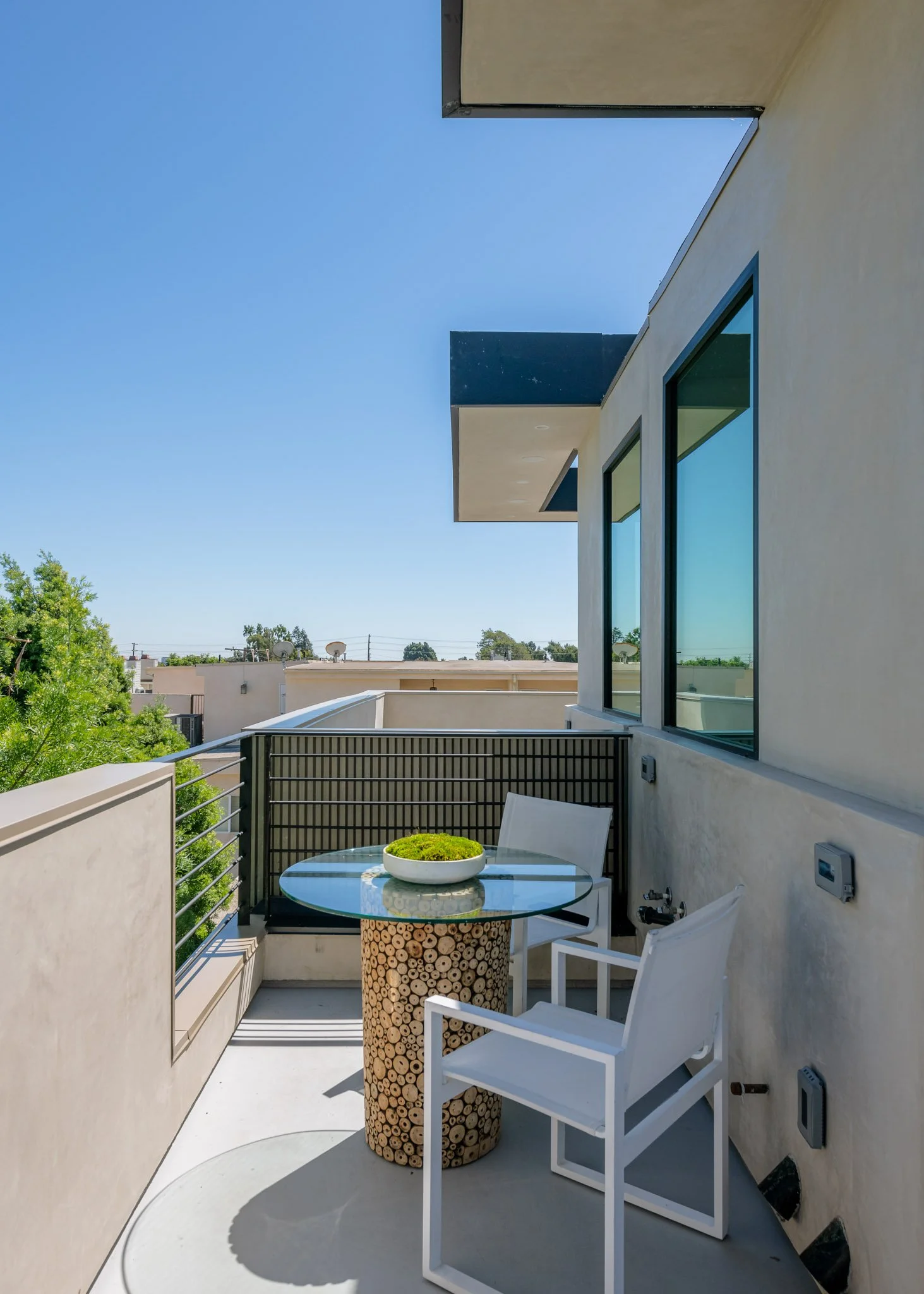 Private balcony designed as a quiet outdoor retreat with contemporary railings and elevated neighborhood views, completed by JBurton General Contractor.