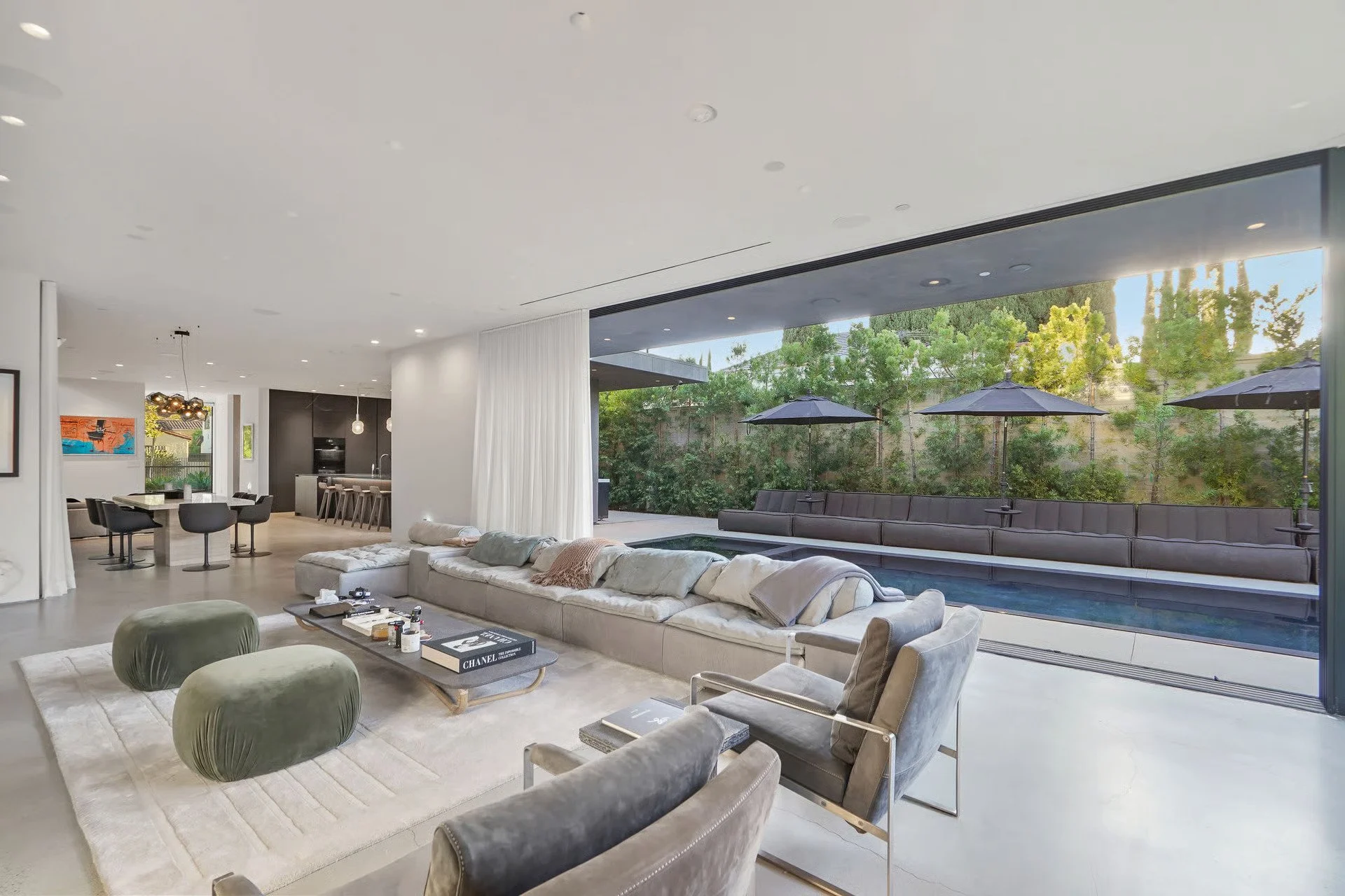 Luxury indoor-outdoor living space with expansive sliding glass doors opening to the backyard, remodeled by JBurton General Contractor in Beverly Grove, Los Angeles.