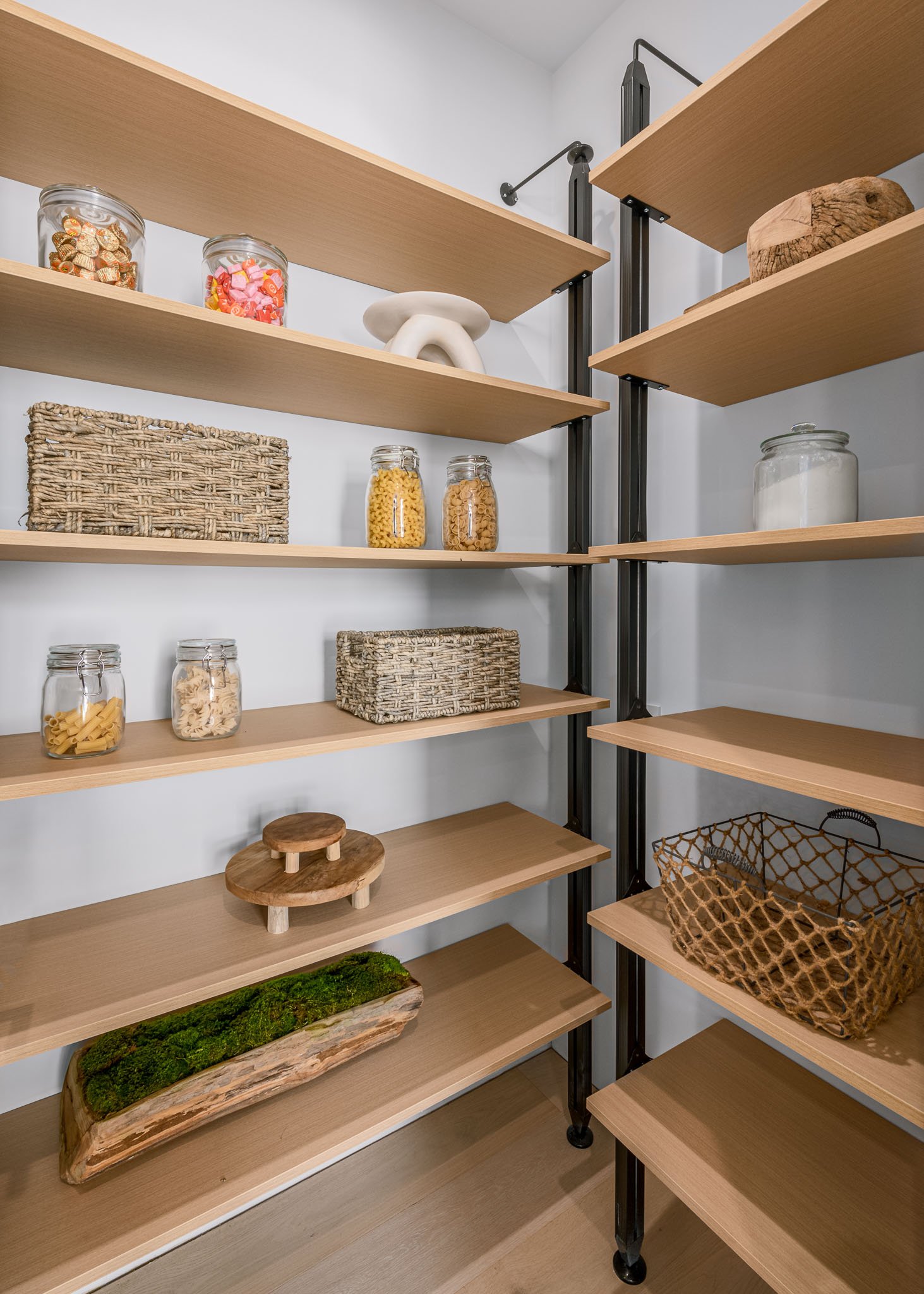 Walk-in pantry with custom wood shelving and thoughtfully designed storage solutions that maximize organization, built by JBurton General Contractor.