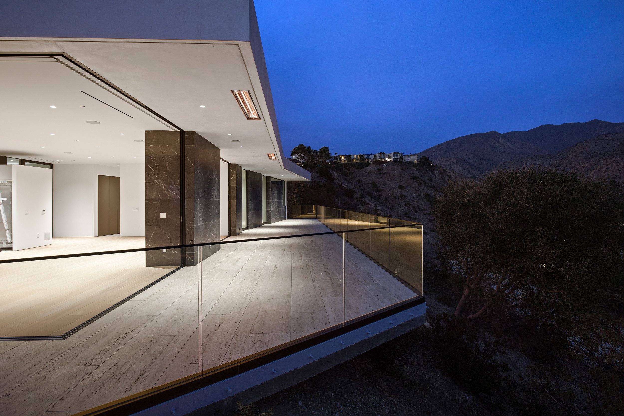 Cantilevered glass balcony engineered to maximize hillside views and create a seamless connection between indoor and outdoor spaces, built by JBurton General Contractor.