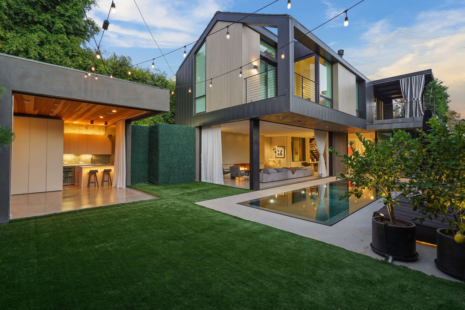 Backyard transformation featuring a swimming pool, covered entertaining pavilion, and expansive indoor-outdoor living spaces completed by JBurton General Contractor.