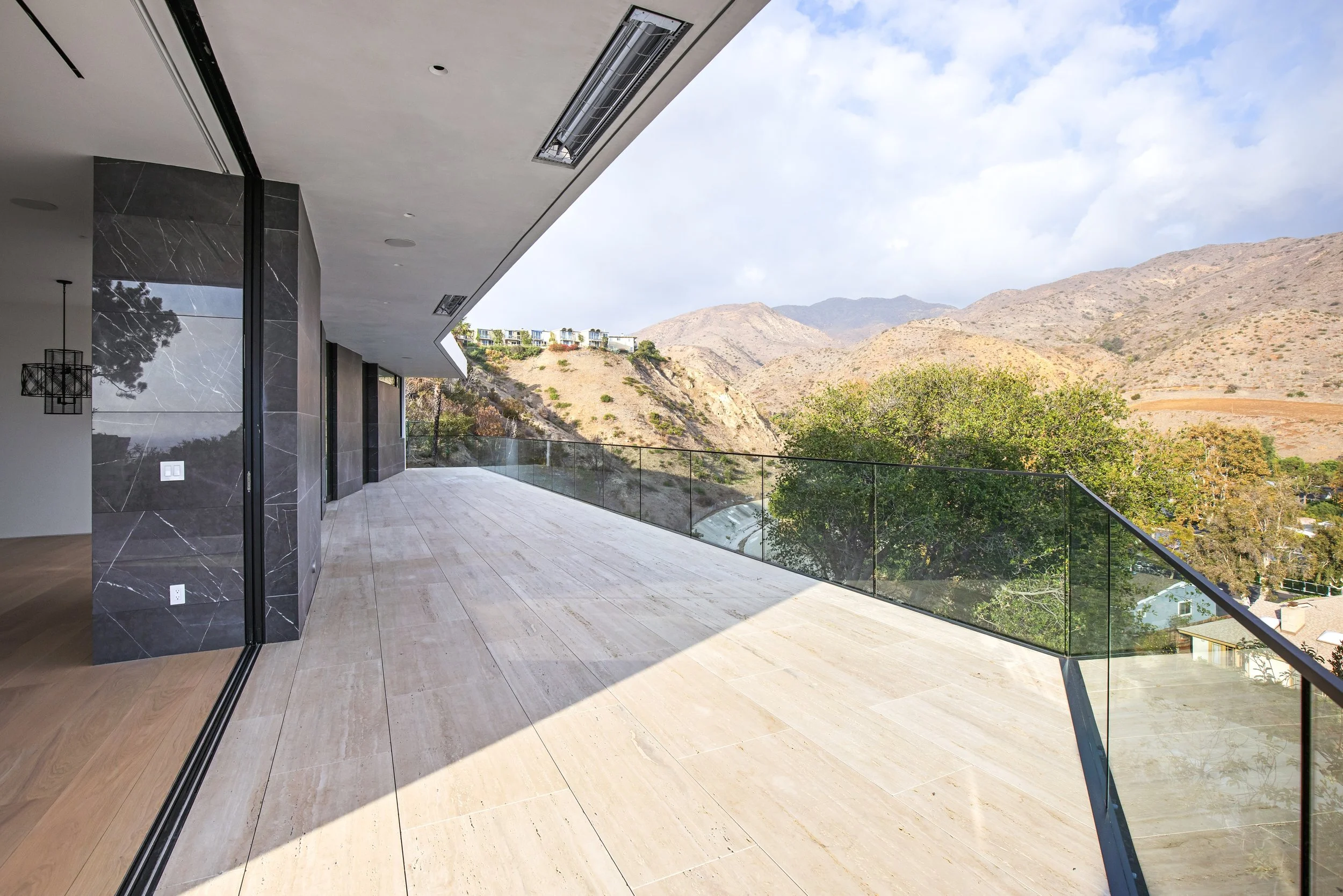 Expansive outdoor terrace with panoramic mountain views at a custom Malibu home built by JBurton General Contractor.