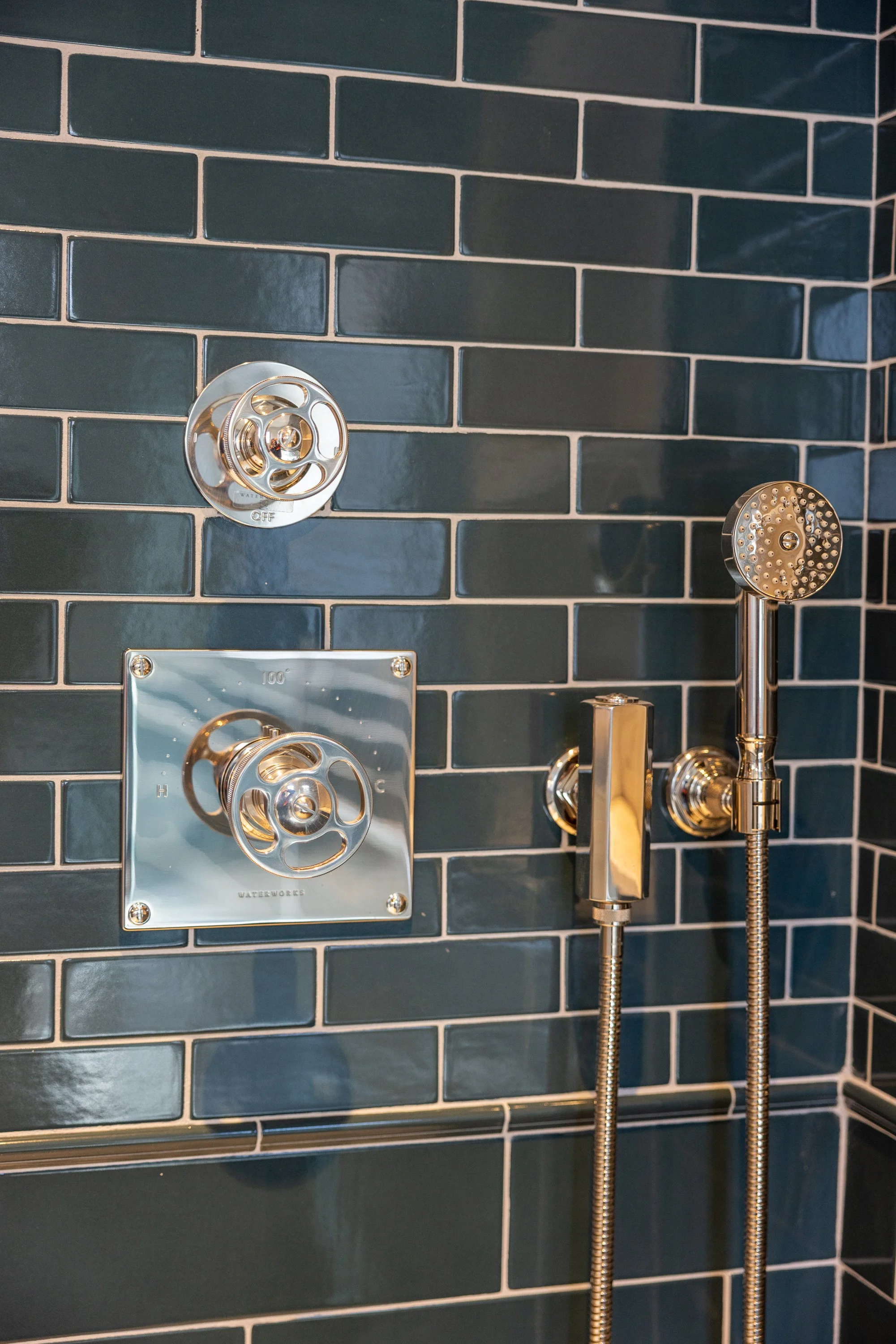 Premium shower fixtures set against deep blue handcrafted tile, showcasing the attention to detail of a Hancock Park renovation by JBurton General Contractor.