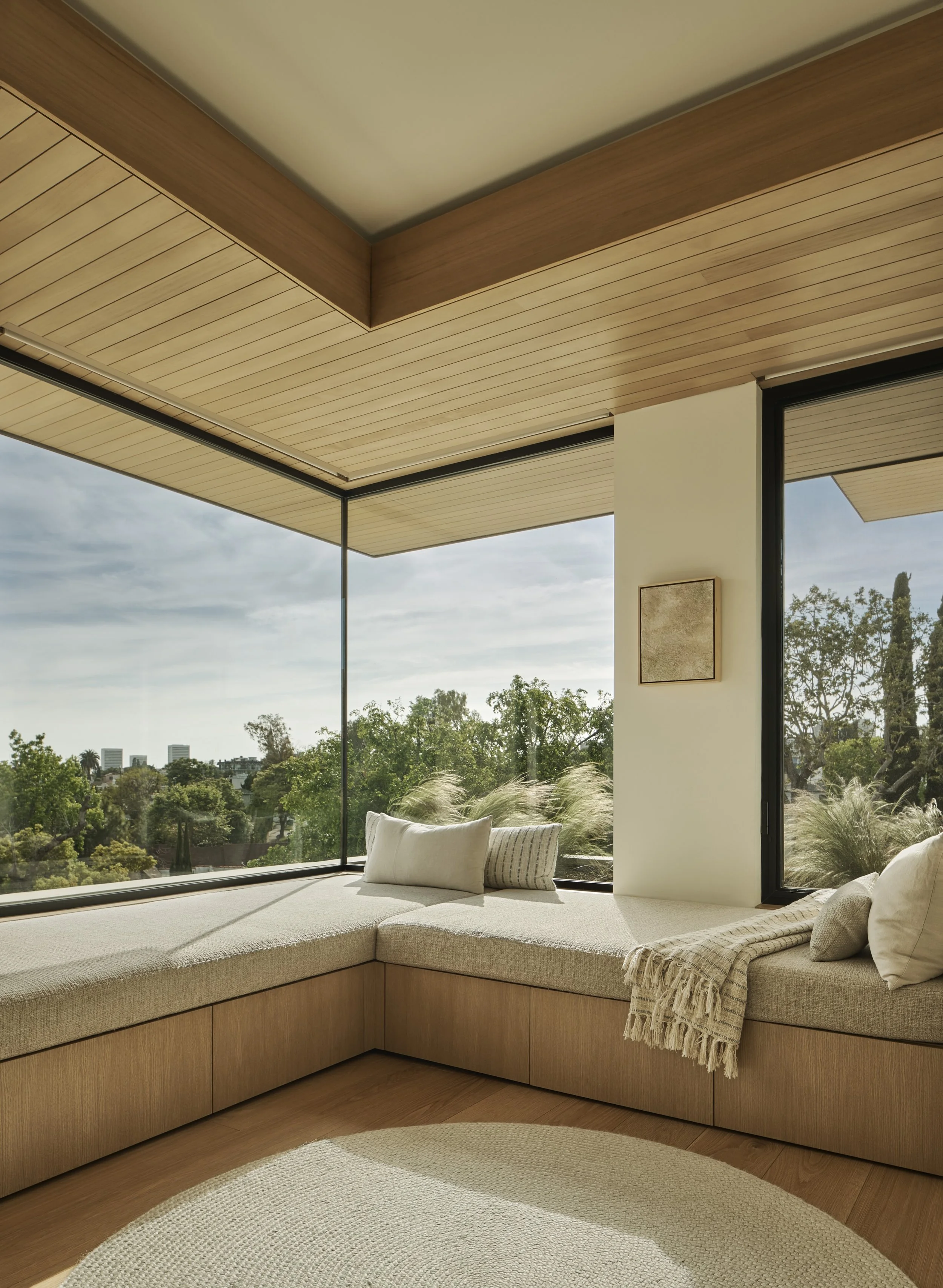 Built-in window seat with floor-to-ceiling corner glazing and custom wood detailing, remodeled by JBurton General Contractor in Beverly Crest, Los Angeles.